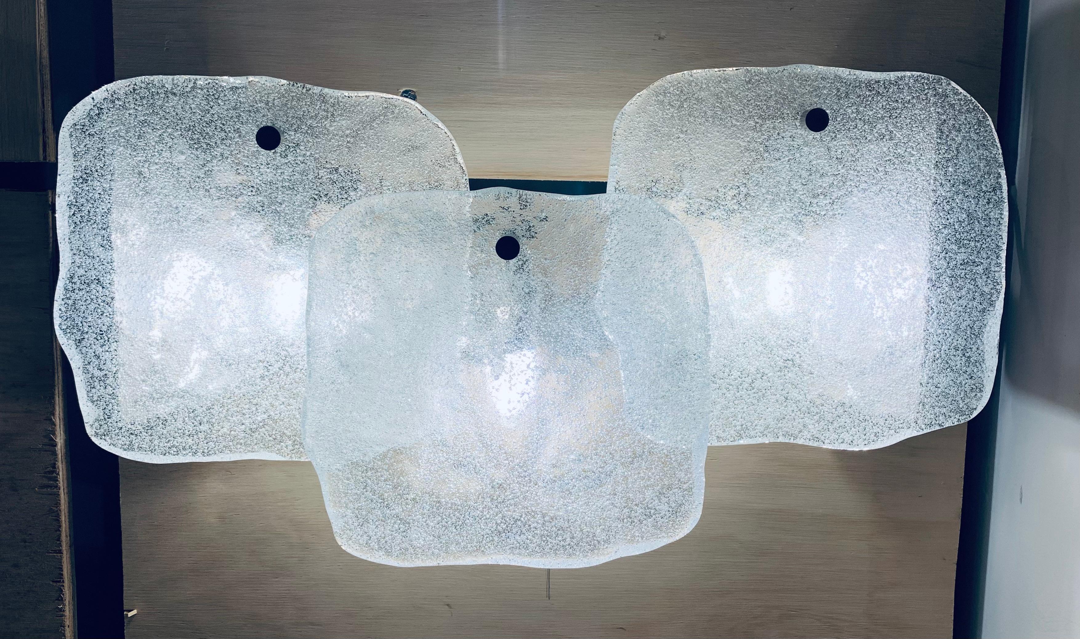 1960s, Austrian, Kalmar Franken KG, wall lights or wall sconces. The three, square, pieces of thick, frosted, iced-glass are suspended from a steel metal frame by a single chrome feature screw at the top of each one. Three E14 screw in bulbs are
