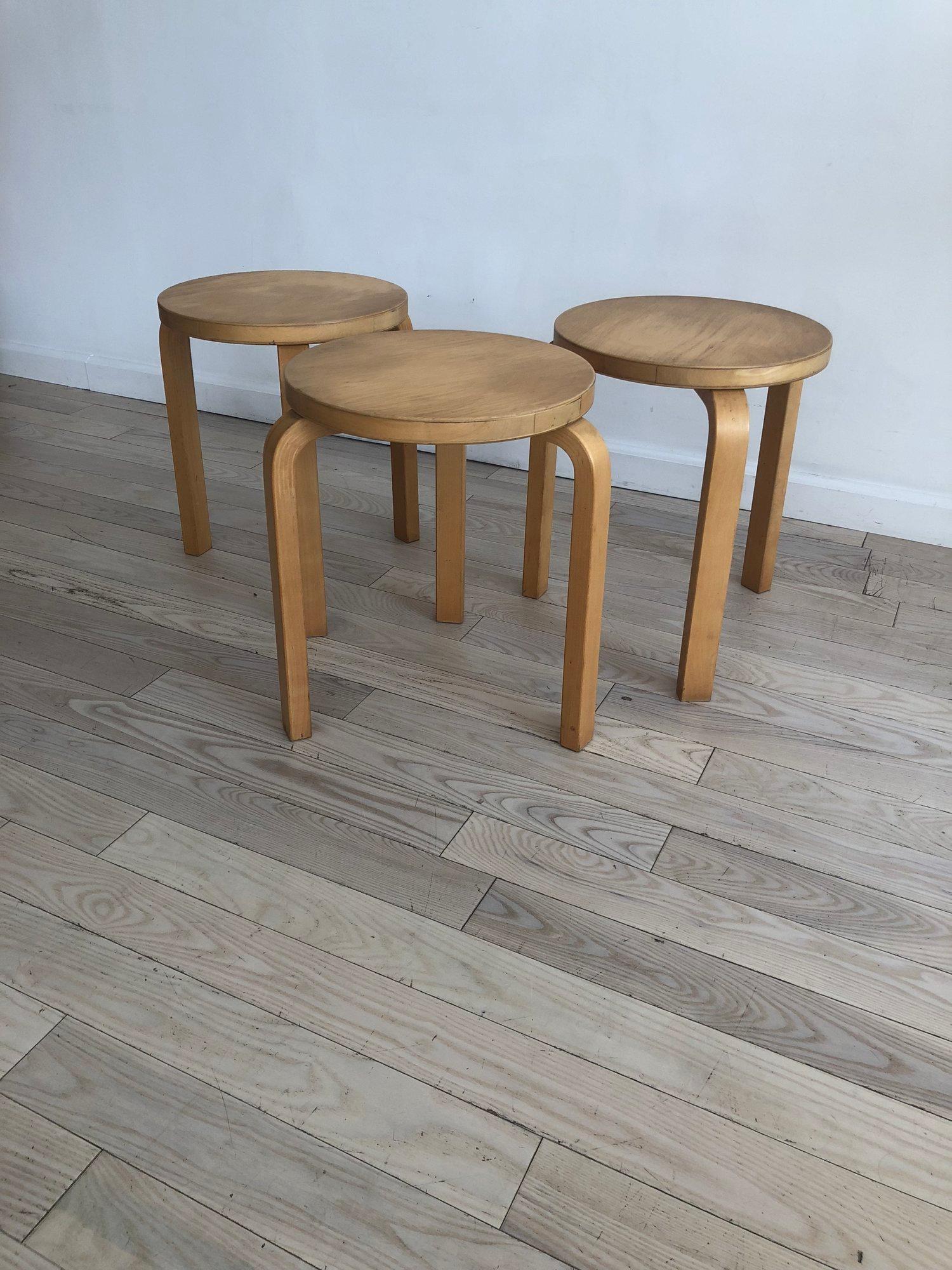 Alvar Aalto set of three Model 60 three-legged stacking stools. Originally designed in 1933. Beechwood, made in Finland. Some signs of age and use on the wood. Minor scuffs. Sold at ICF, this set of from the 1960s. Marked Alvar Aalto on the bottoms.