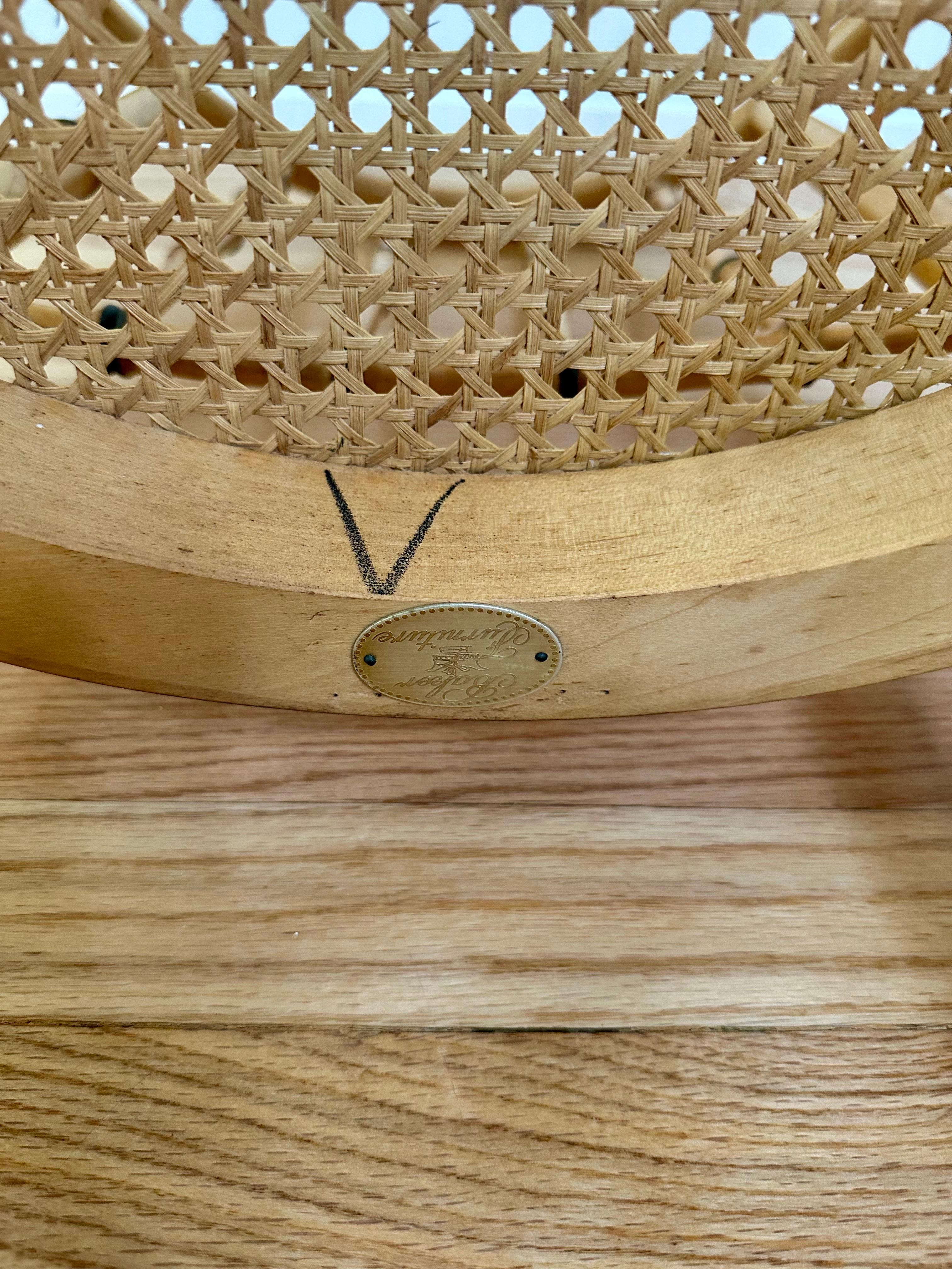 Nos complace ofrecerte un sillón vintage de Baker Furniture, de la década de 1960. Presenta el célebre diseño de bambú sintético de la marca, con detalles de huso torneado y un acabado en tono miel realzado por sutiles toques negros. El respaldo