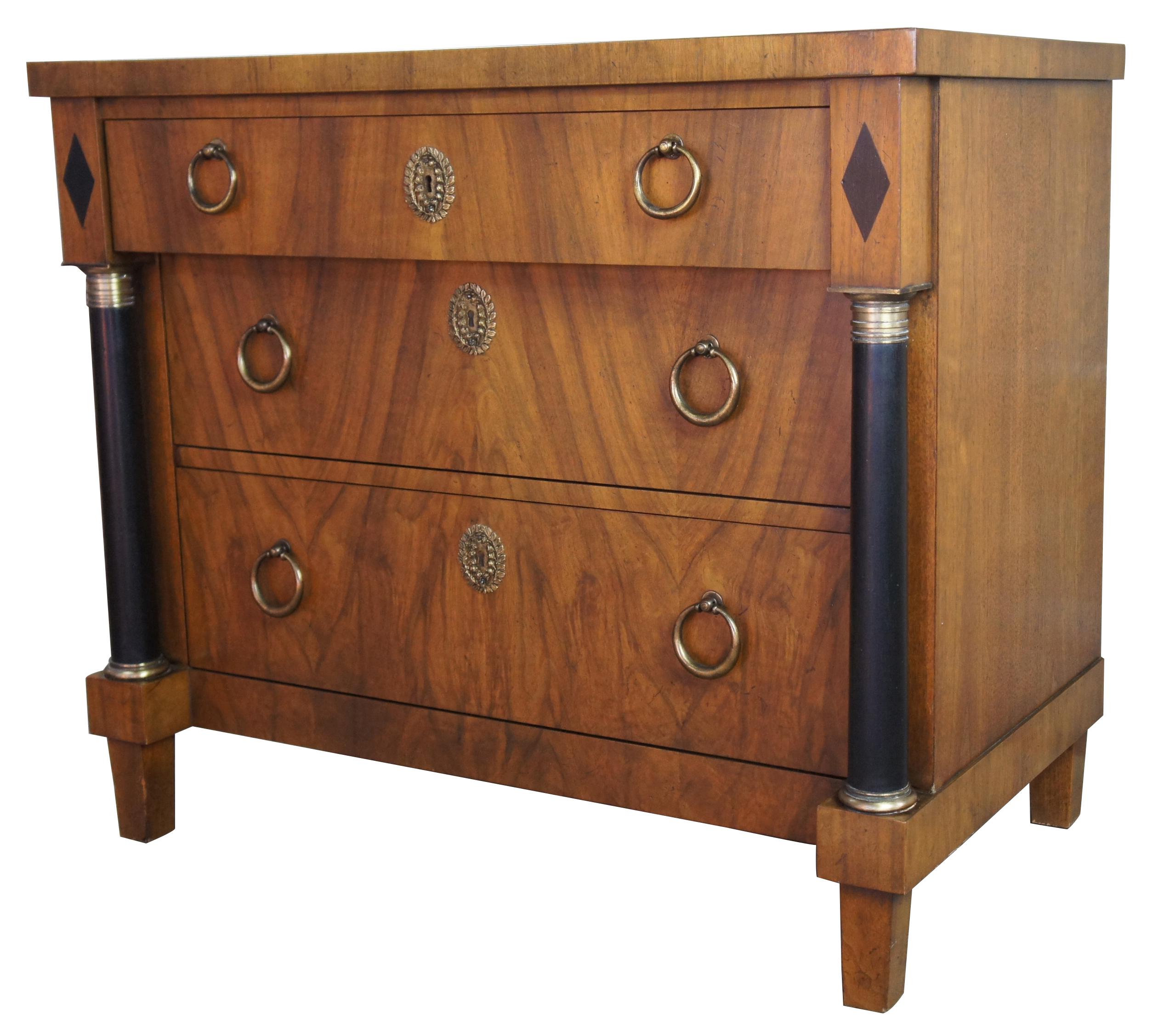 1960s Baker Furniture French Empire Biedermeier walnut 3-drawer chest commode

French Empire style dresser by Baker Furniture, circa 1960s. Made from walnut with ebonized and brass columns along front, brass keyhole plates, and decorative brass