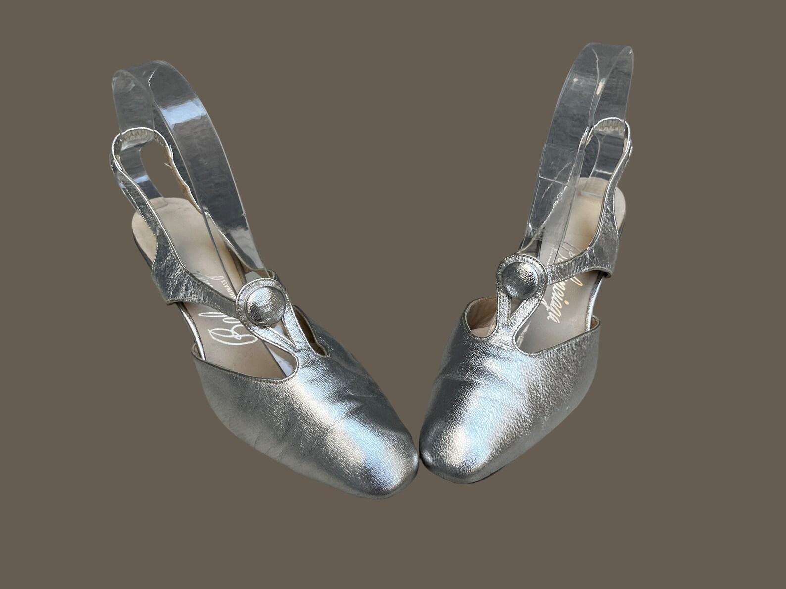 Beautiful & rare Balenciaga silver leather slingback kitten heels. 
Cut-out vamp with a decorative button at the center. 
Handmade leather.

★ An amazing piece of fashion history!

Circa 1960s
Balenciaga
Custom Originals
Marked Size