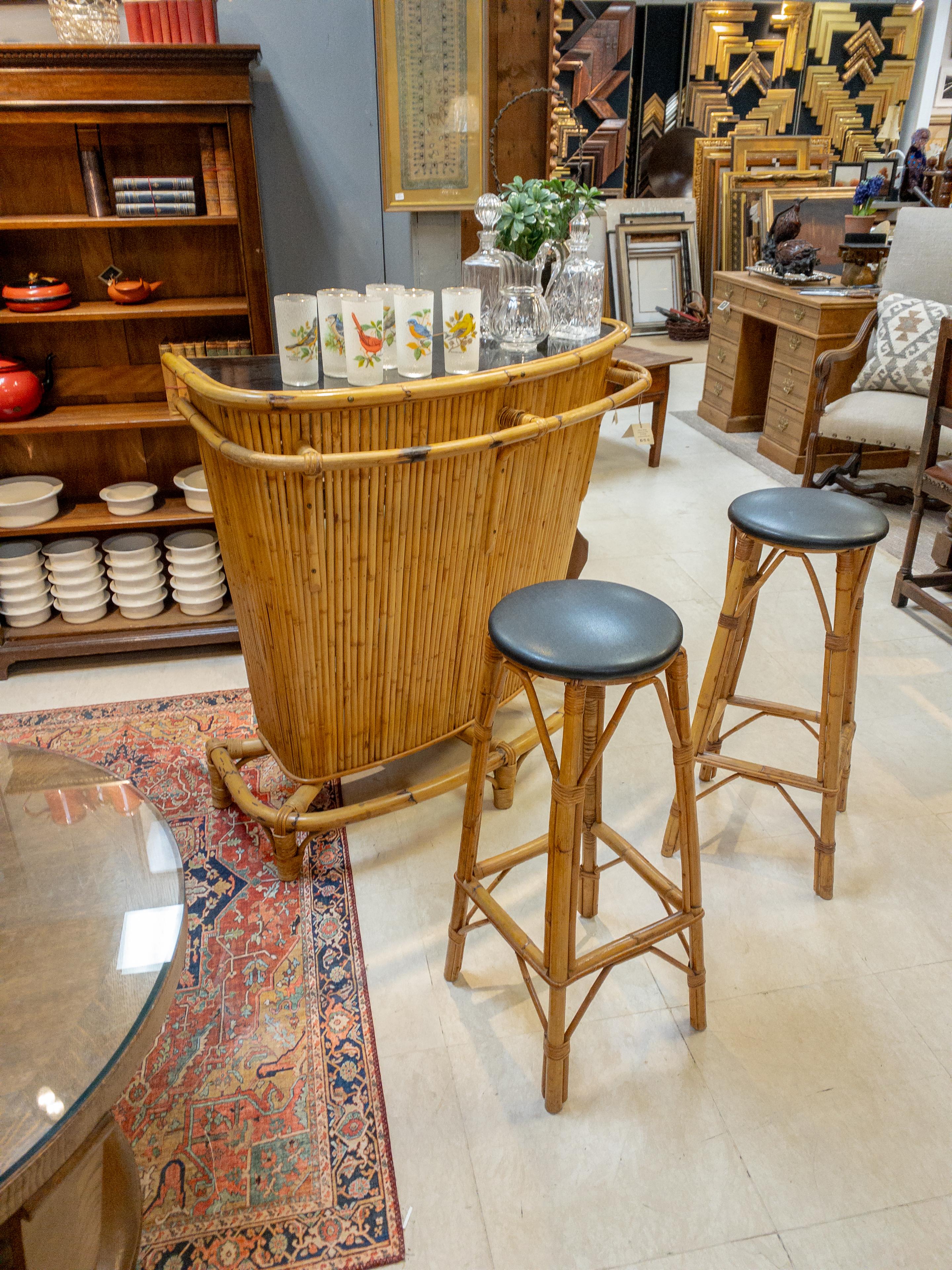 Transport yourself back to the swinging 1960s with this charming Bamboo Bar and Stools set. The epitome of retro chic, the bar boasts a sleek Formica top surface, perfect for mixing cocktails or serving snacks. Its body, crafted from scorched