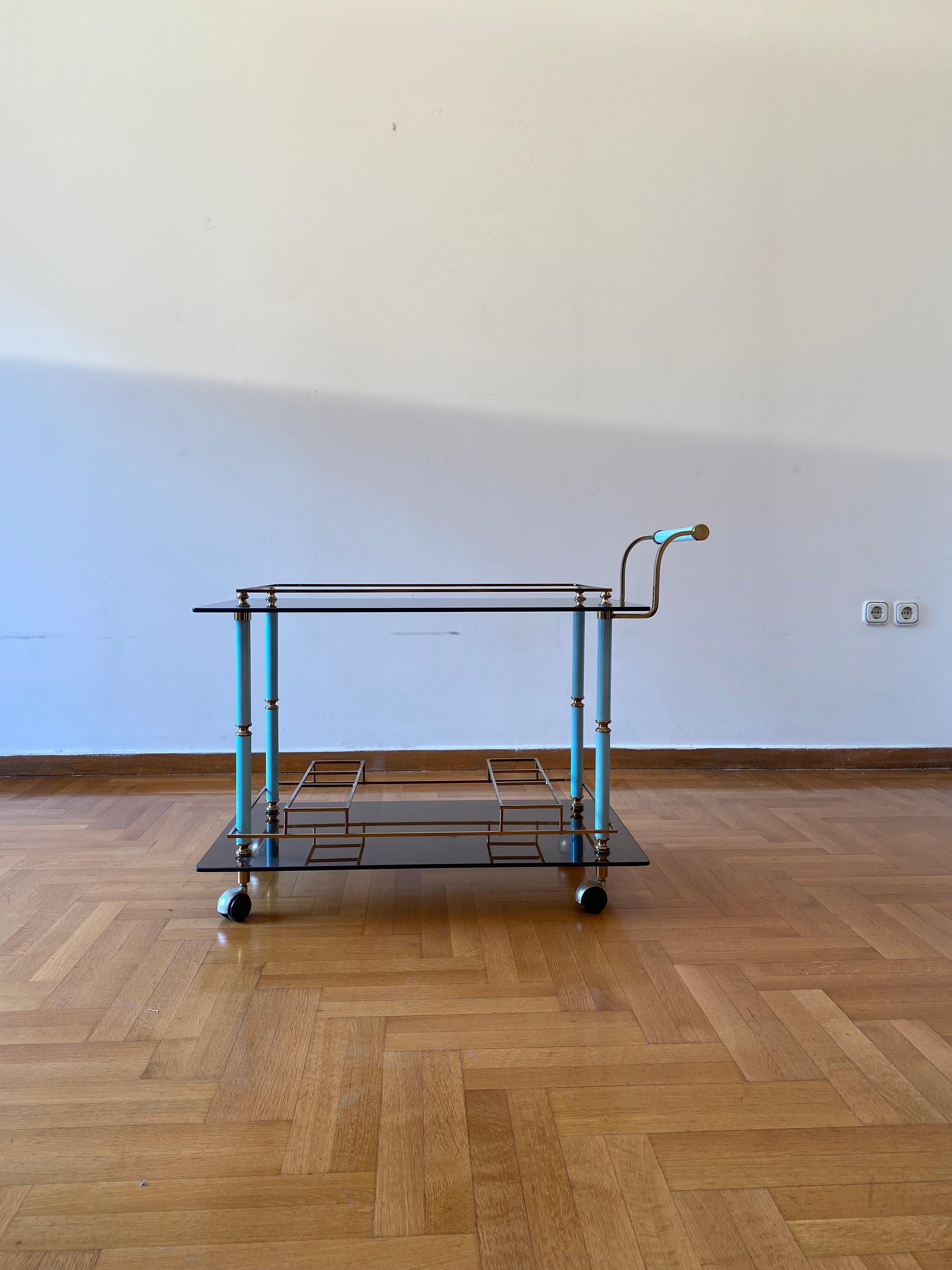 Exquis chariot de bar du milieu du siècle des années 1960, doté d'un cadre en laiton étincelant et d'insertions carrées distinctives pour les bouteilles sur le niveau inférieur, conçu pour contenir et présenter les spiritueux en toute sécurité. Là