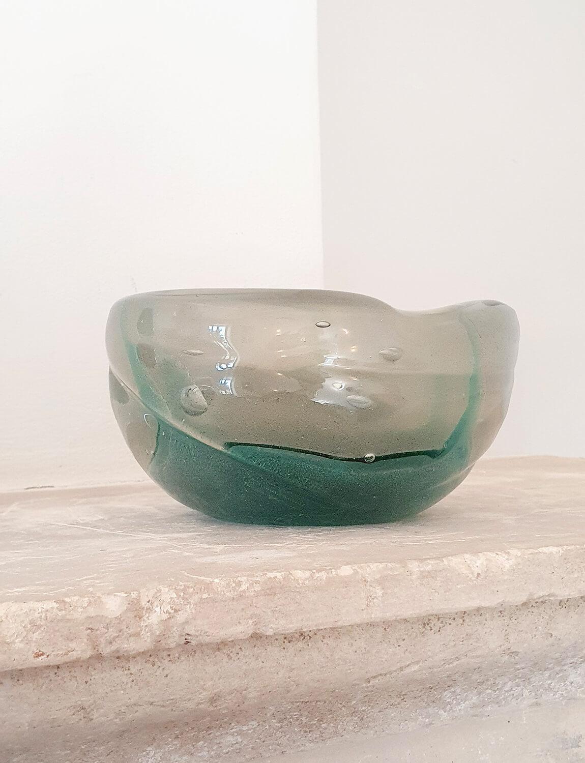 This bowl was made by the renowned glass designers Barovier & Toso in the 1960s in Murano. It is a pleasing heavy organic shape with a deep emerald green flourish and gold leaf throughout the hand-blown glass. There are visible decoratve air bubbles