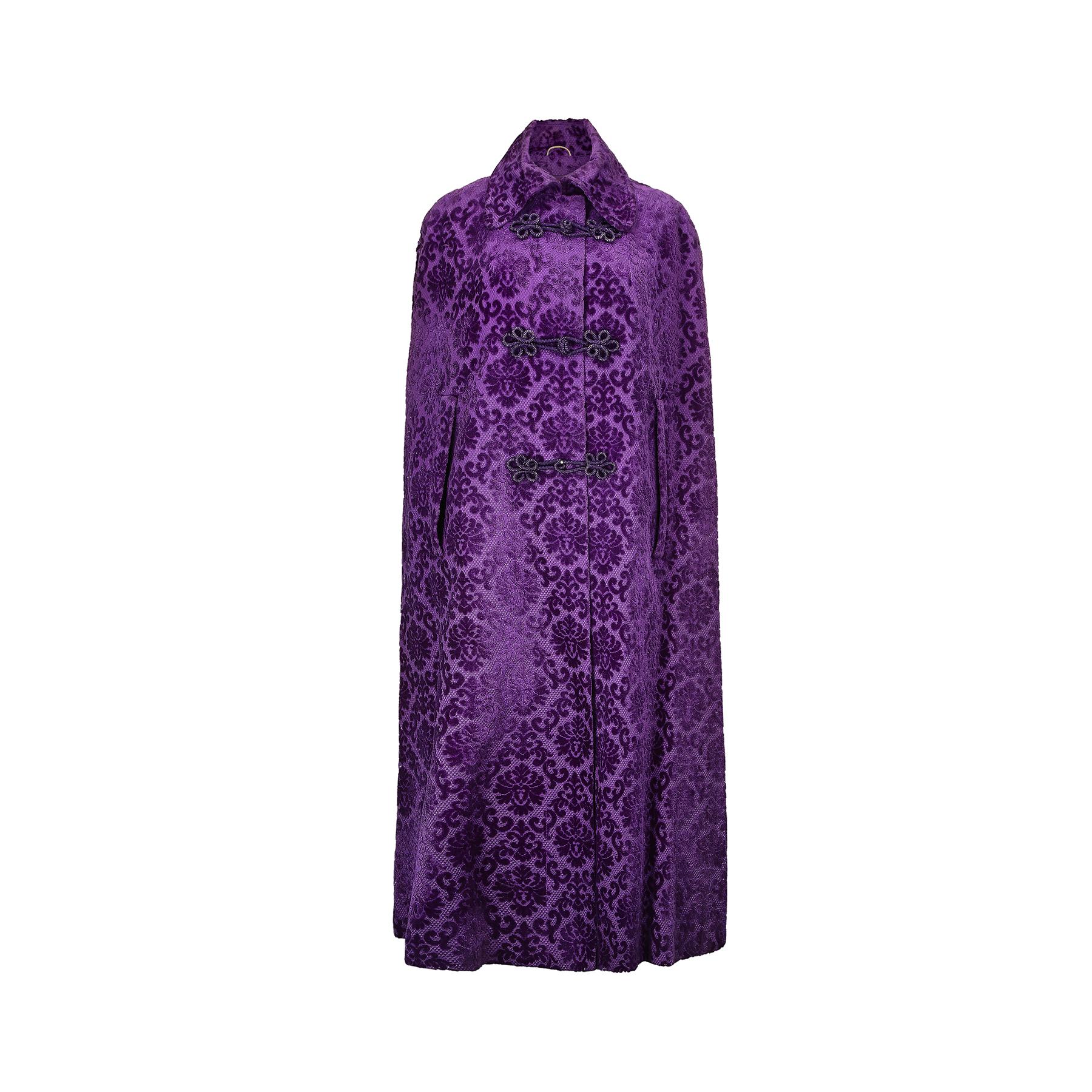This purple embossed velvet cape was made in England during the height of the swinging 60s London boutique scene by Carnaby Street designer, Barry Sherrard. It features a large rounded collar, with a mixture of buttons and thick rope frog fastenings