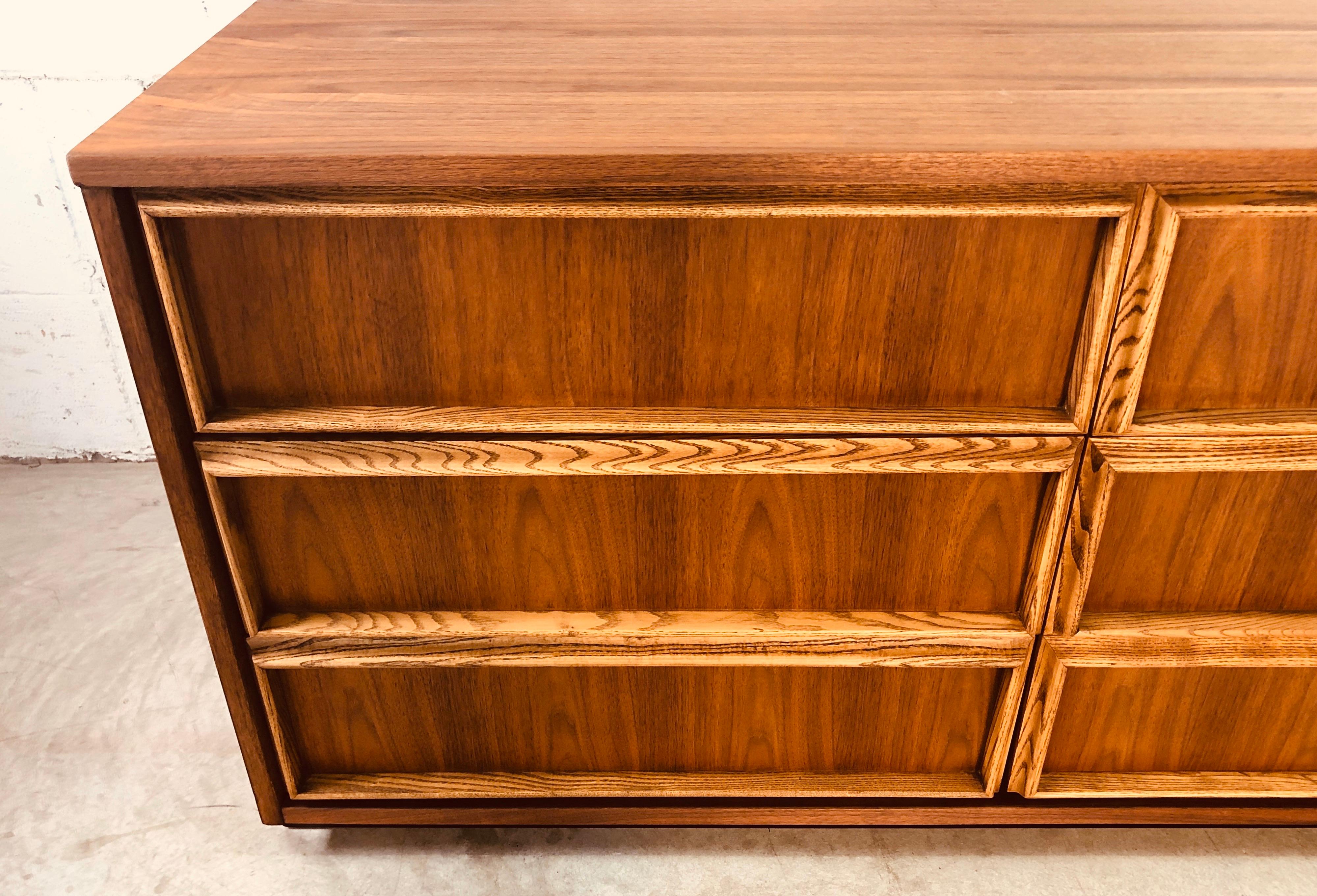 Vintage 1960s Bassett Furniture walnut and ash wood low dresser with 6-drawers. The ashwood accents all 6-drawers and the dresser floats on a black painted base. Newly refinished and in excellent condition. Marked in the drawer.