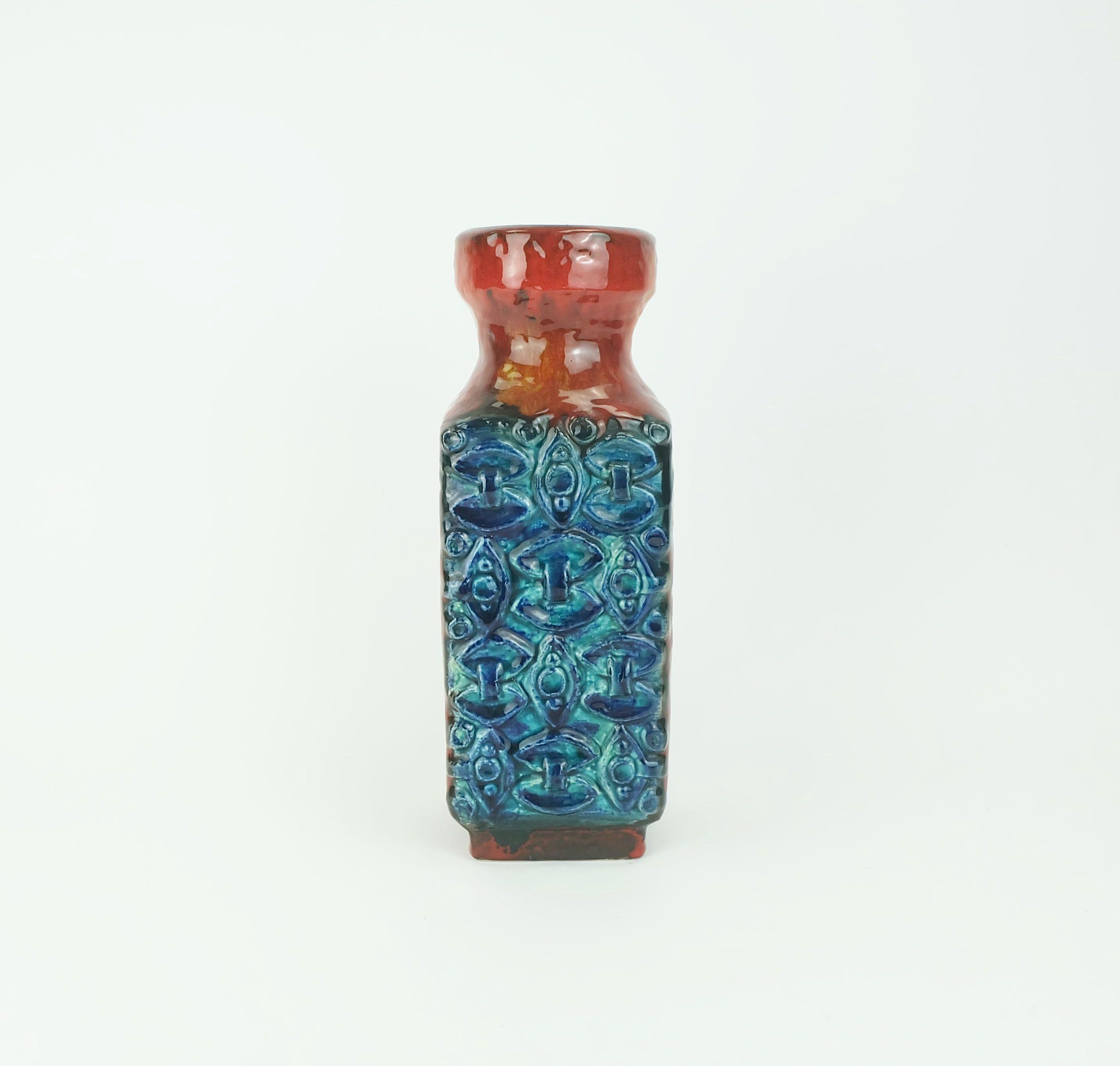 Fantastico vaso vintage in ceramica della Germania occidentale prodotto da Bay Keramik negli anni '60. Smalto a goccia rosso e arancione combinato con decorazioni a rilievo nei toni del blu e del turchese. Numero di modello 986-30. 

Dimensioni in