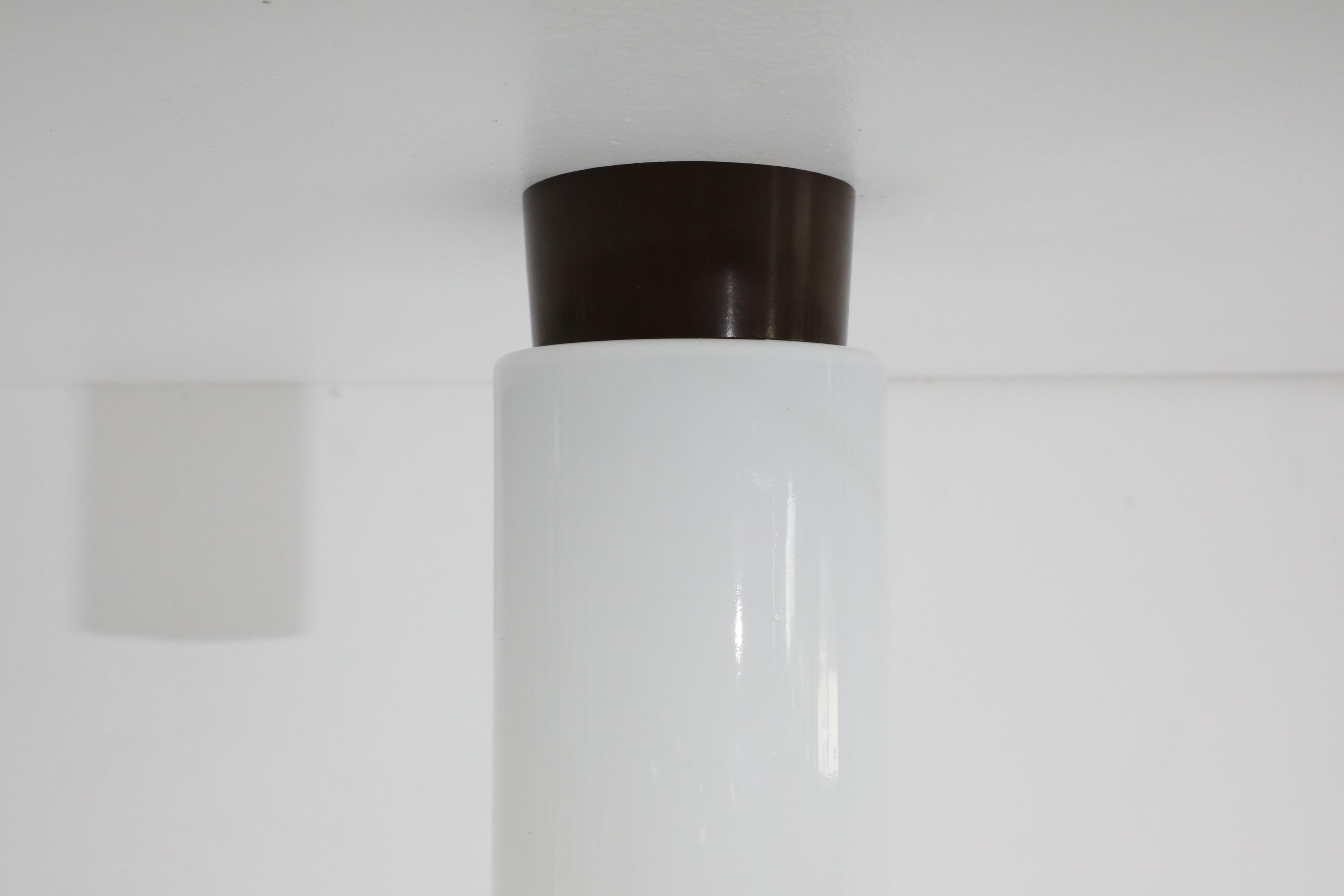 Verre opalin Applique tubulaire en verre opalin blanc sur base en bakélite Brown foncé, style Whitinga, années 1960 en vente