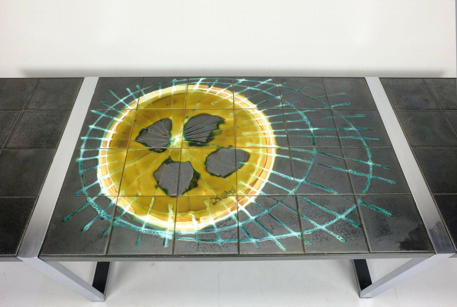 Fantastic and very beautiful late 1960s coffeetable by Belarti. Top ceramic tiles in dark grey with a slight metallic shine, motif in ochre, white and turquoise, embedded in a metal rim. The base is made of chrome plated metal.

Very good