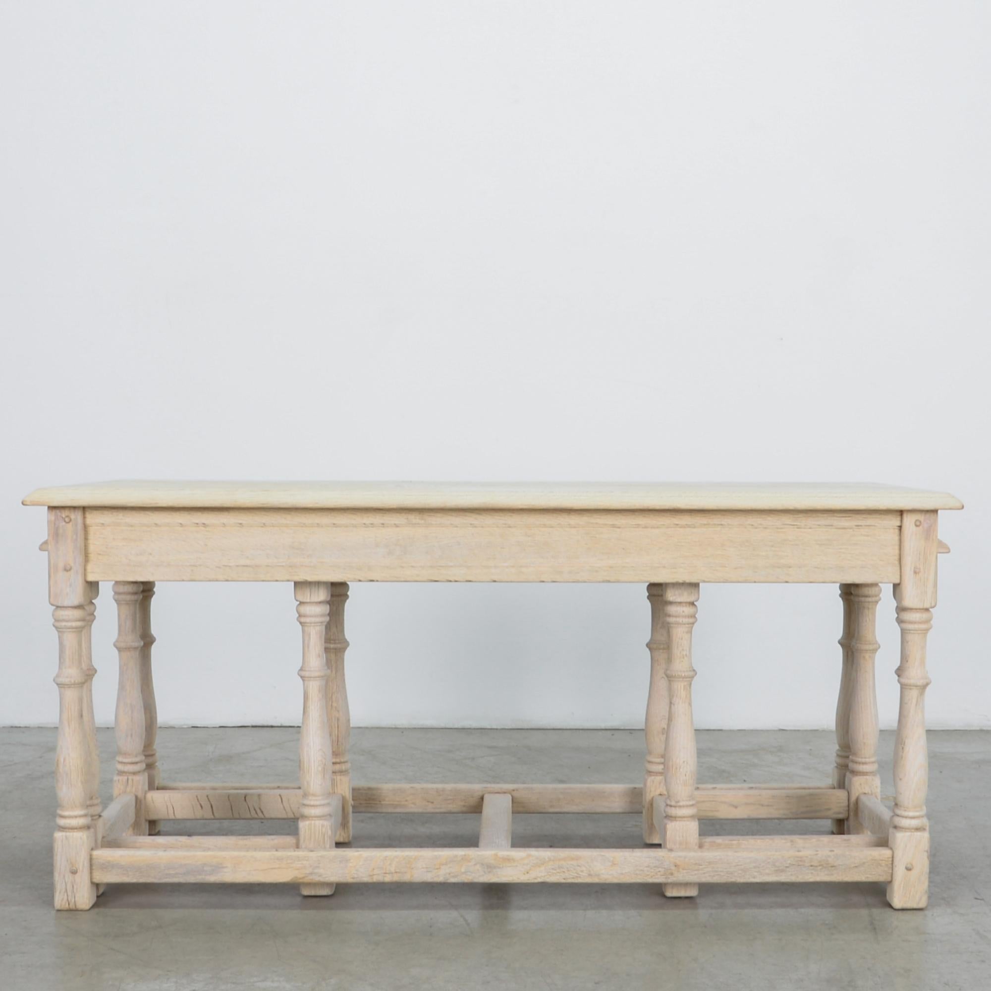A sturdy long table in oak, from 1960s Belgium. With unique nesting configuration, two small square tables can be stowed from either end. Sturdy construction and subtle ornament follows the lineage of European craftsmen, with wood turn legs and