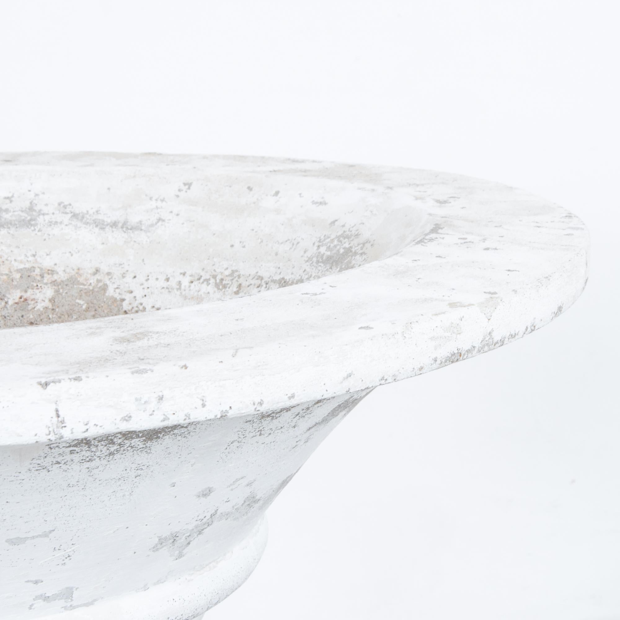This trumpet-shaped concrete planter with a solid, circular foot was made in Belgium, circa 1960. Ribs encircling the body accentuate its pleasing curve. The distressed, white patina lends a rustic touch to the planter’s understated elegance.