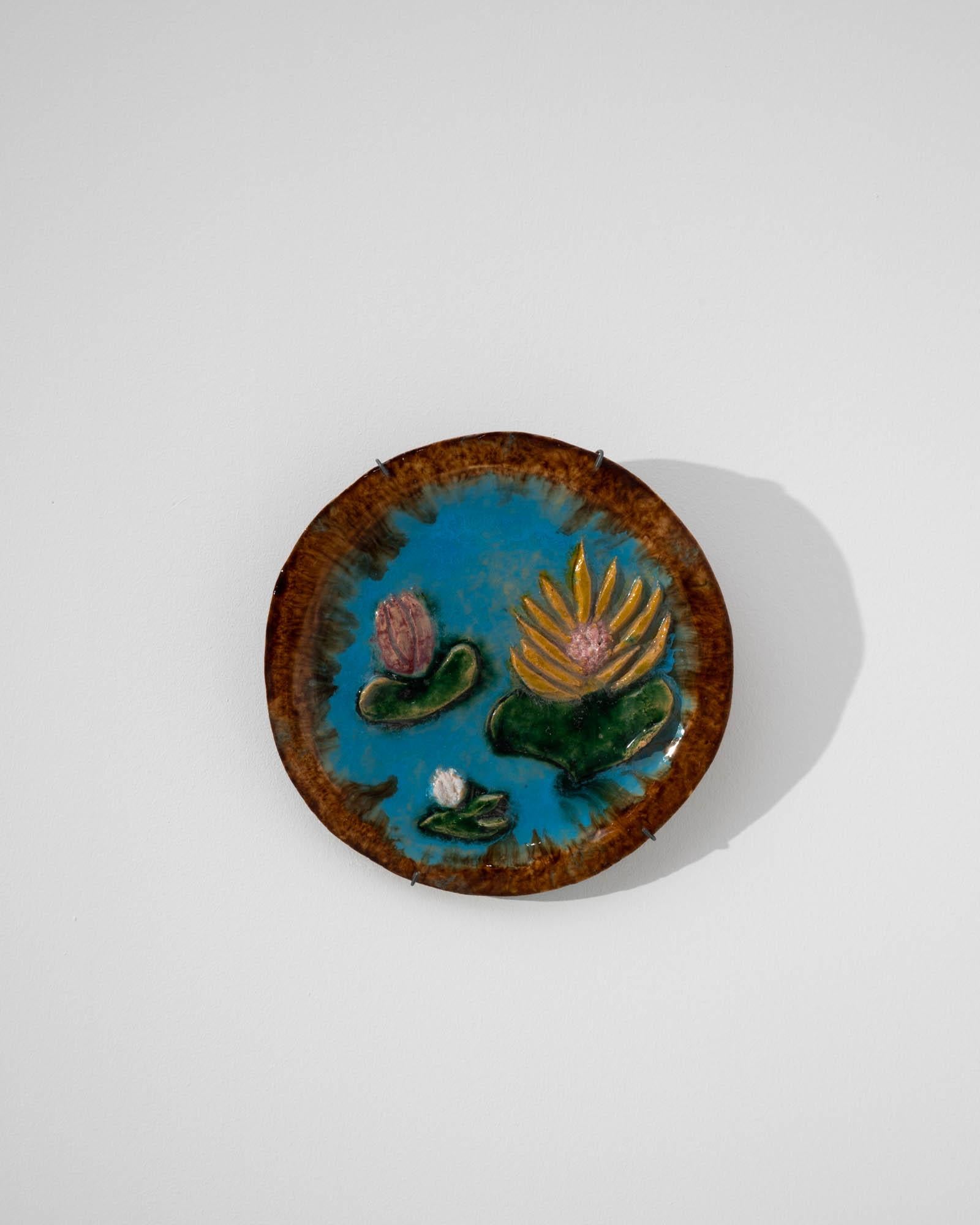 A ceramic wall decoration created in 1960s Belgium. Pastel, brimming with 1960s charm, with a tasteful patina, enigmatically playful wall decoration brings warmth and a decorative flair to the room. Three lily pads, with colorful flowers, wreathed