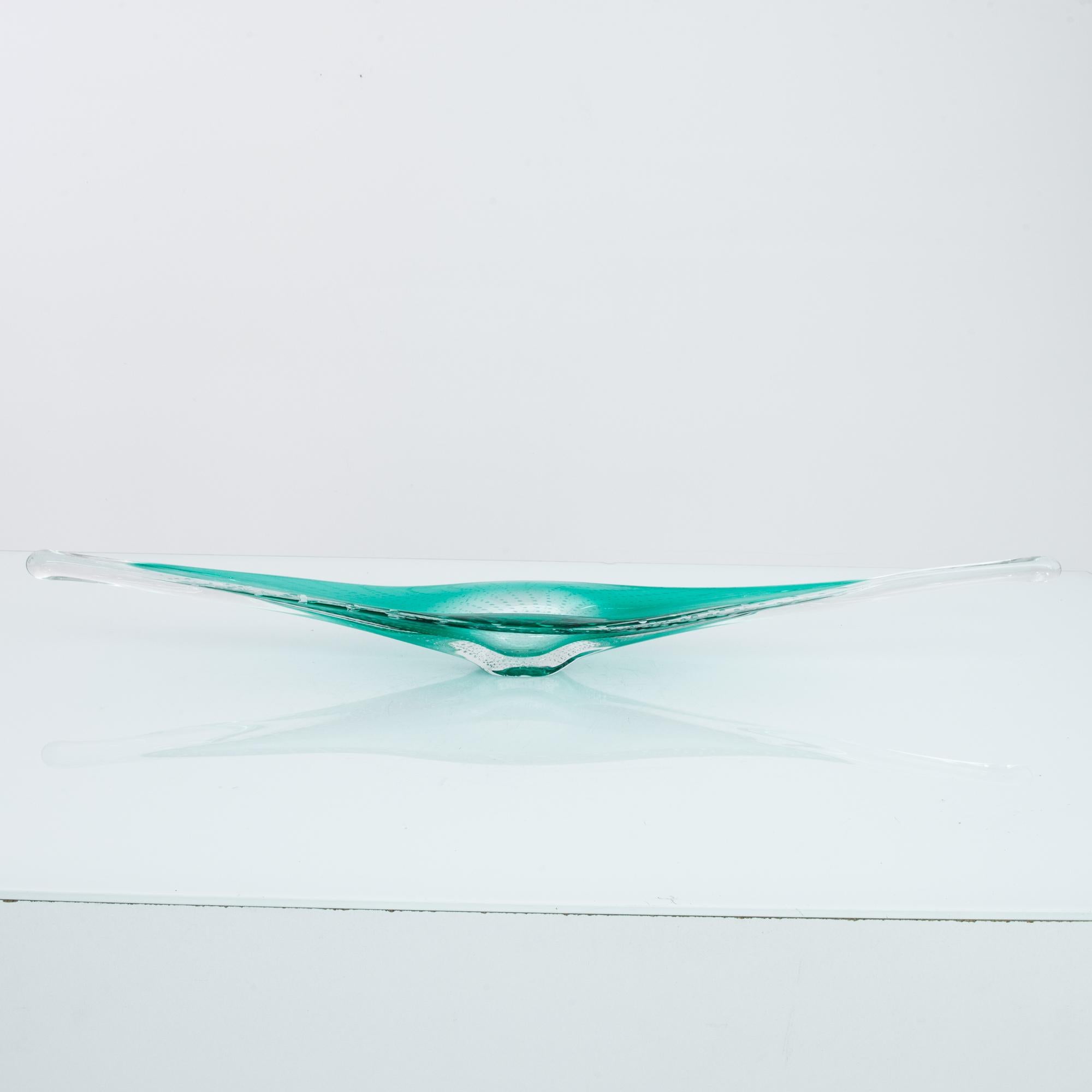 A glass bowl from Belgium, produced circa 1960. An elegant, hand blown decorative glass bowl in a rich rich color, veins of bubbles flowing throughout-- frozen in motion. Sat upon the table like the symbolic divine chalice, the sacred feminine, this