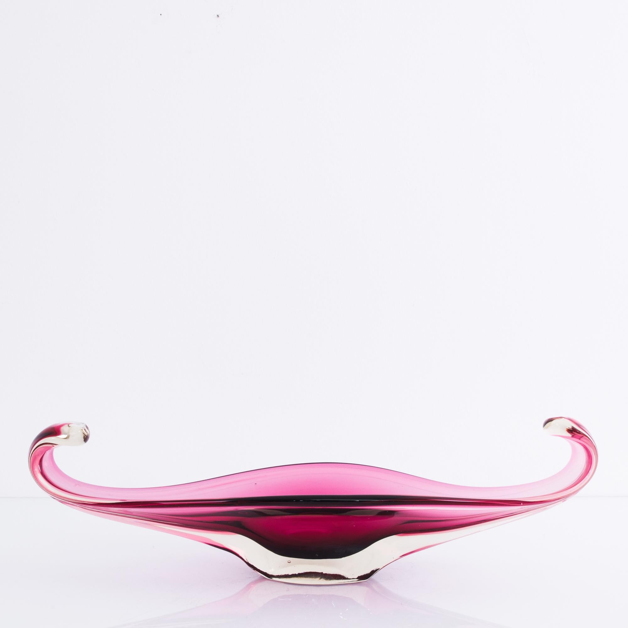 A glass bowl from Belgium, produced circa 1960. An elegant, hand blown decorative glass bowl in a rich magenta color. Sat upon the table like the symbolic divine chalice, the sacred feminine, this perfectly balanced piece delights with its shape and