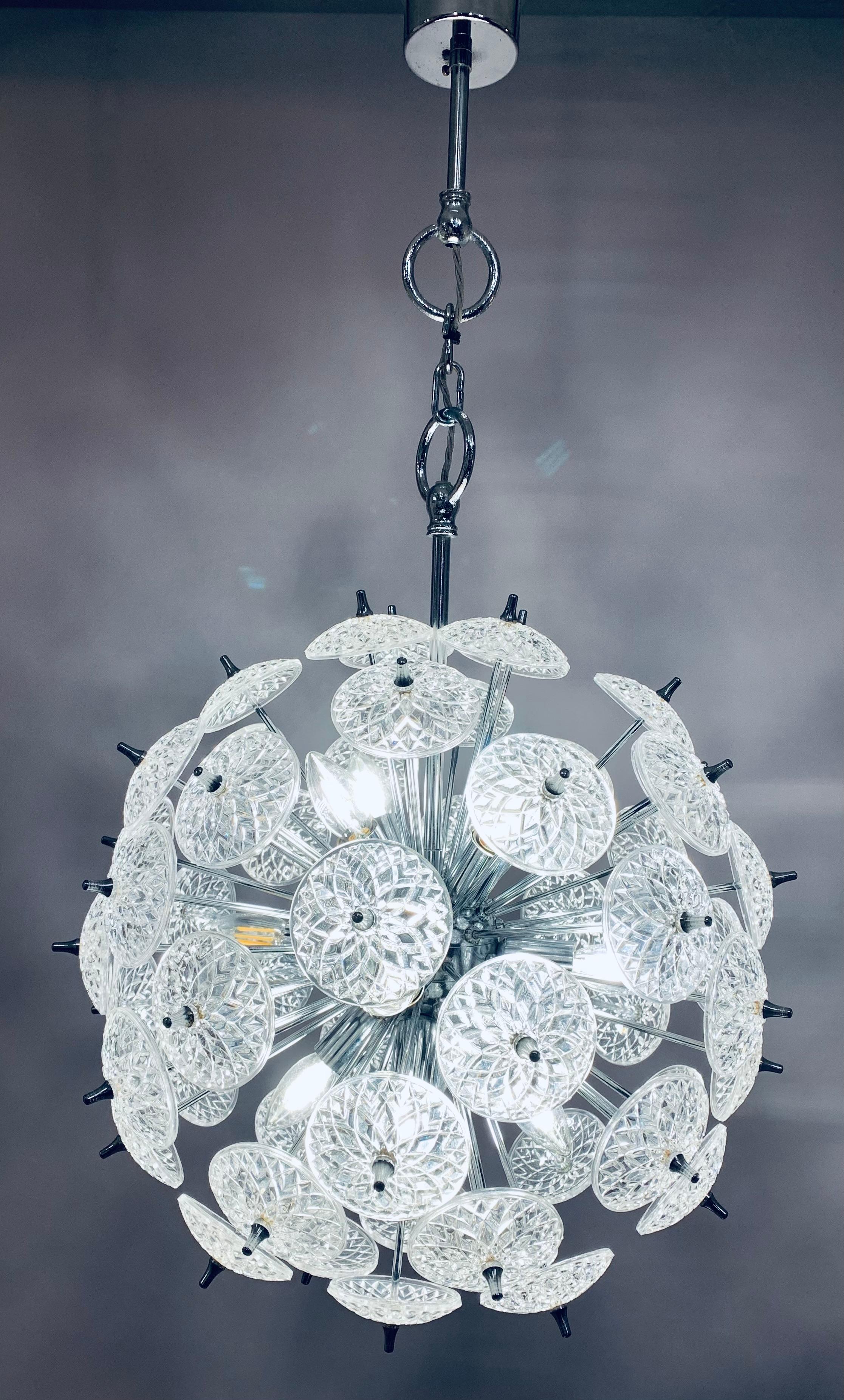 1960s Belgium Val Saint Lambert sputnik chandelier with individual cut-glass crystal discs which are supported at the end of a number of rods which are all connect to a sphere at the centre. 12 bulbs illuminate the polished chromed-metal frame which