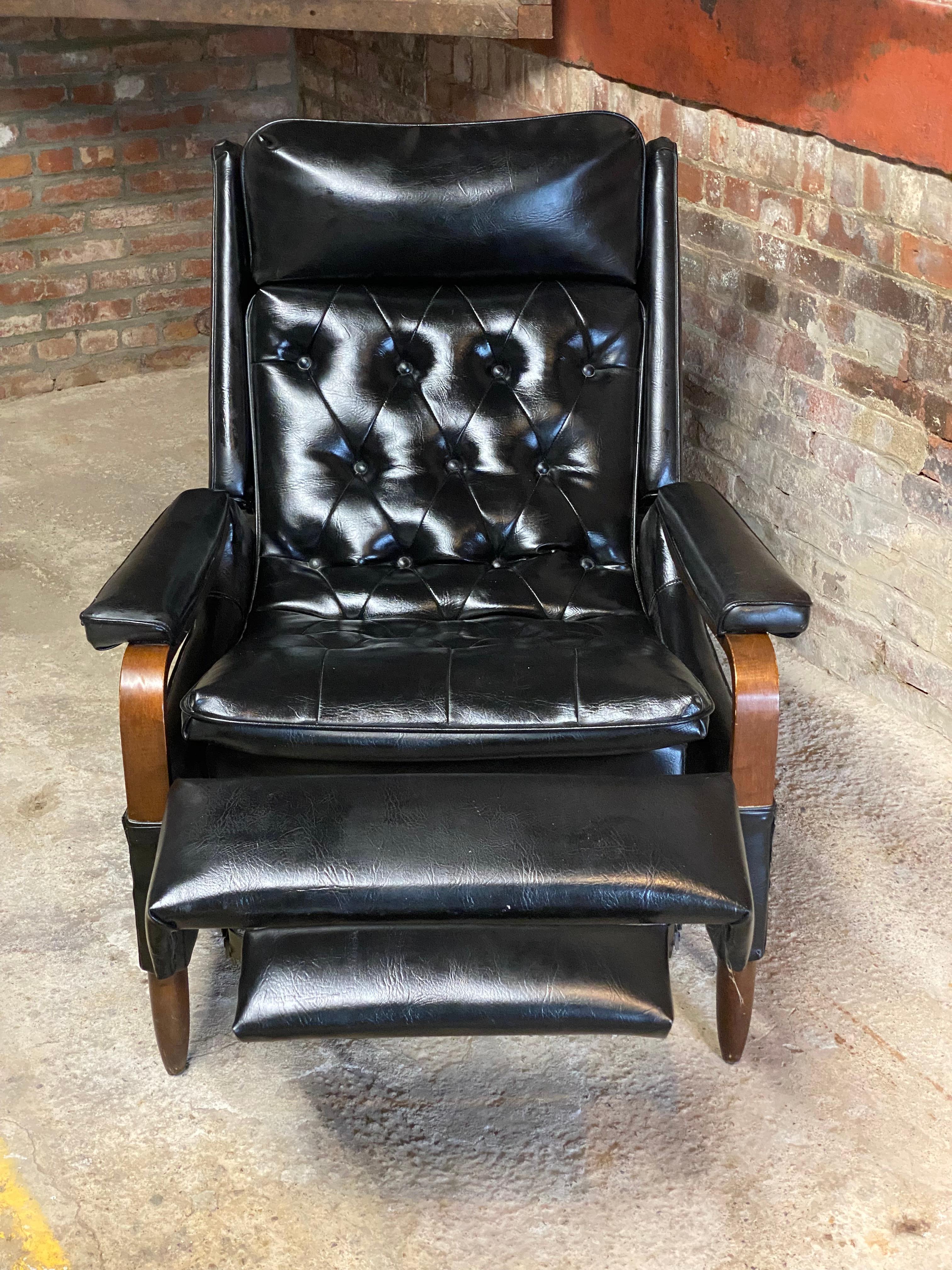 A truly comfortable and stylish chair. Circa 1960s bentwood arm with tufted and buttoned seat and back. Black vinyl upholstery. Nicely cushioned head and arm rests. Tapered and rounded wood legs. Great for the TV and movie binge watcher or the