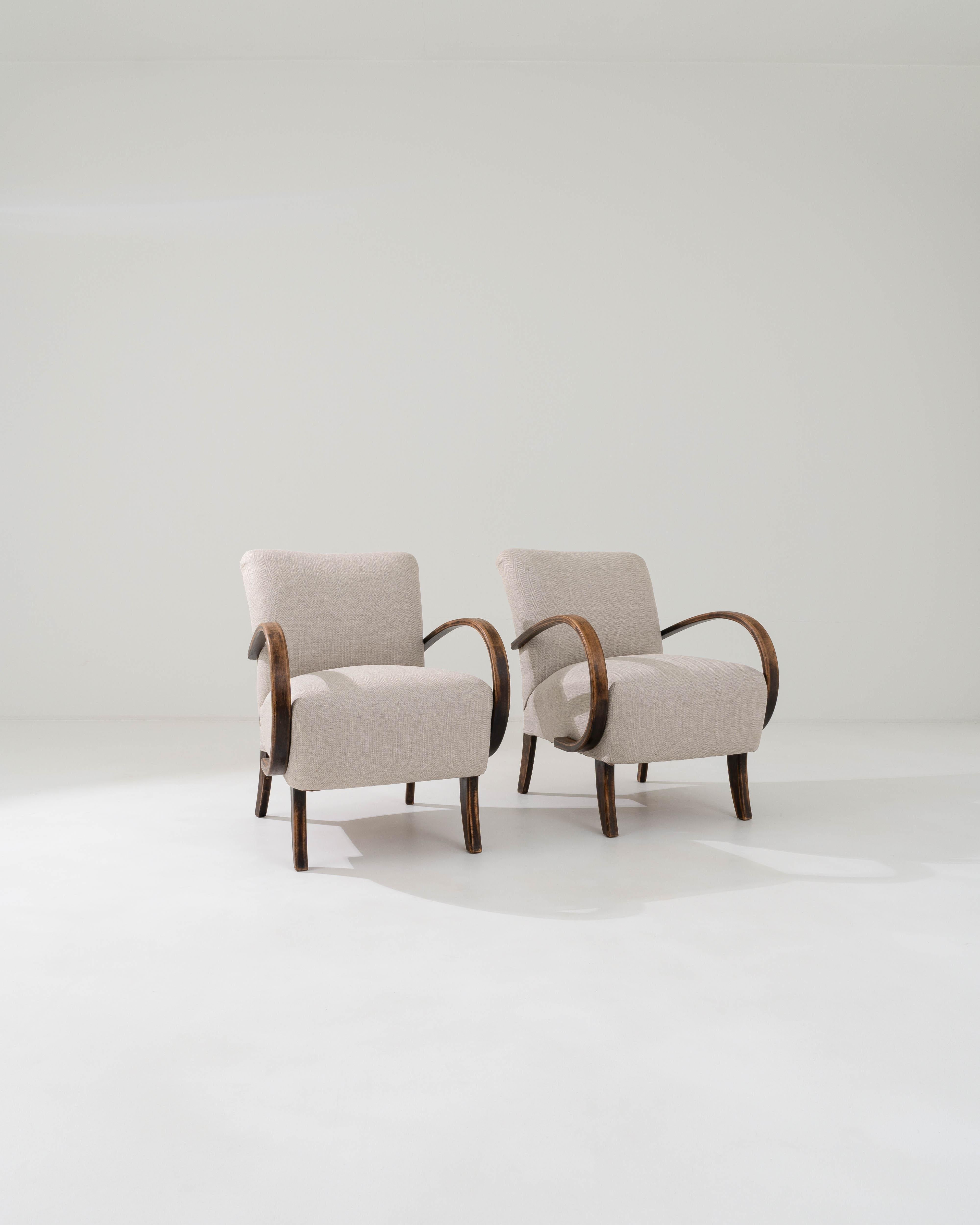 Vintage wooden frame combines with updated beige upholstery in this iconic design by J. Halabala. This early ‘type-C’ chair design was produced throughout the 20th century, and flaunts playful contrasts of color, texture and shape. The chair’s