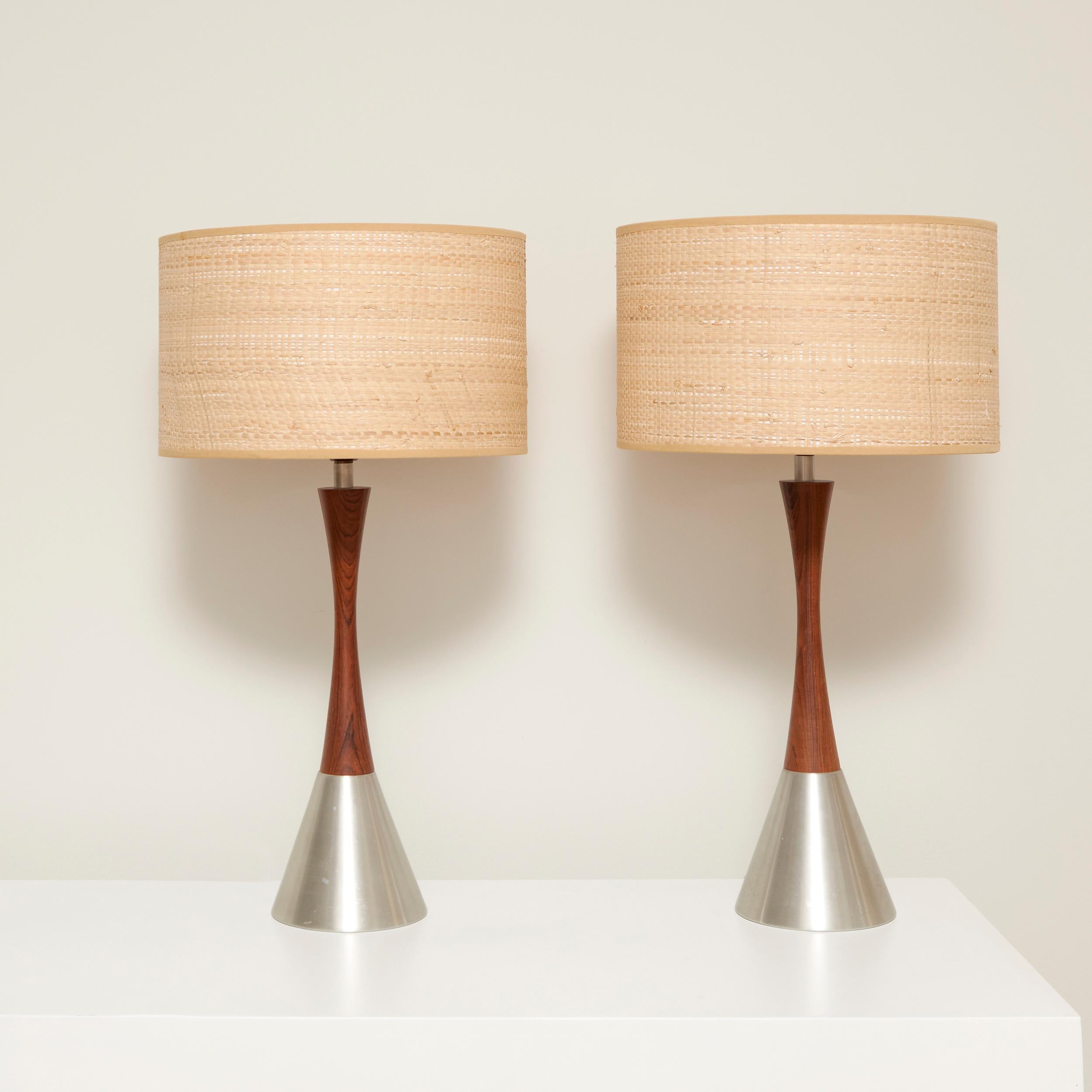 Pair of table Lamps in Rosewood and steel in a double side tapered shape combining manufactured by bergboms. Sweden, 60’s. 
Excellent vintage condition that may present slight traces of use. New Lampshade in raffia. completely functional 

This