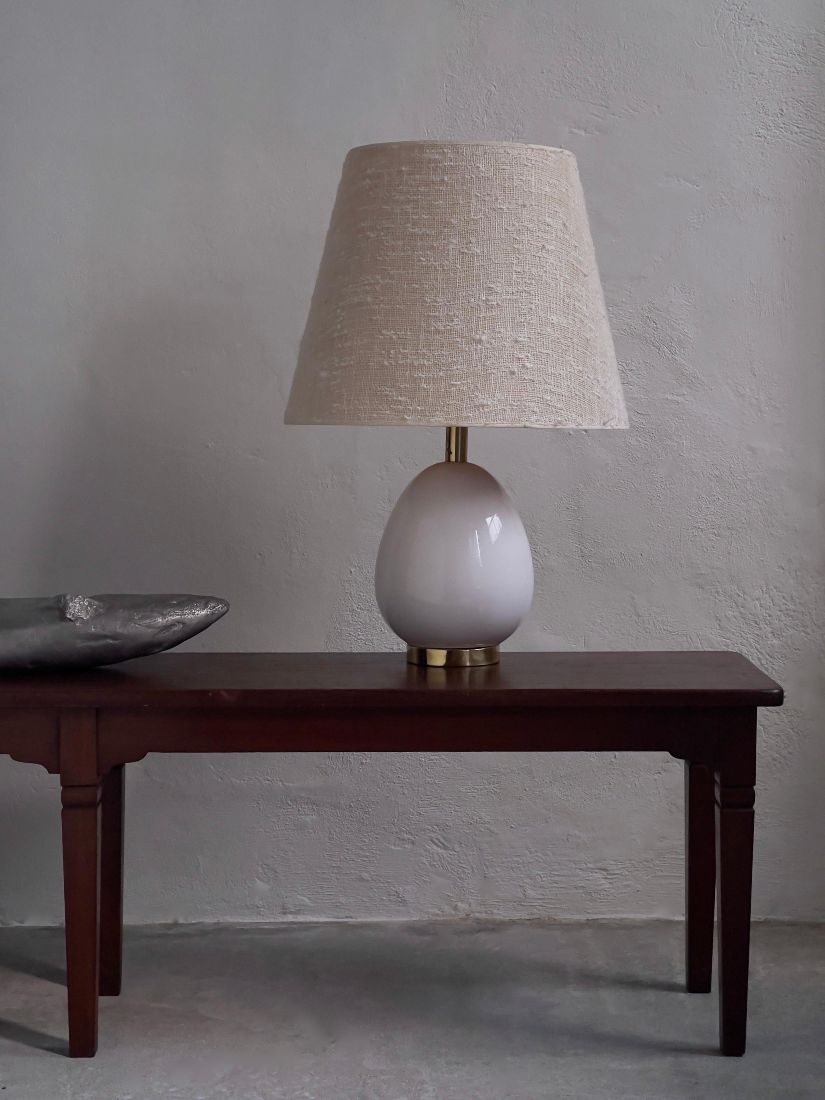 Rare scandinavian mid century white glazed ceramic table lamp with solid brass base and middle part. This impressive Swedish manufactured lamp by renowned Bergboms in the 1960s is in great condition with only minor dent in the solid brass base. The