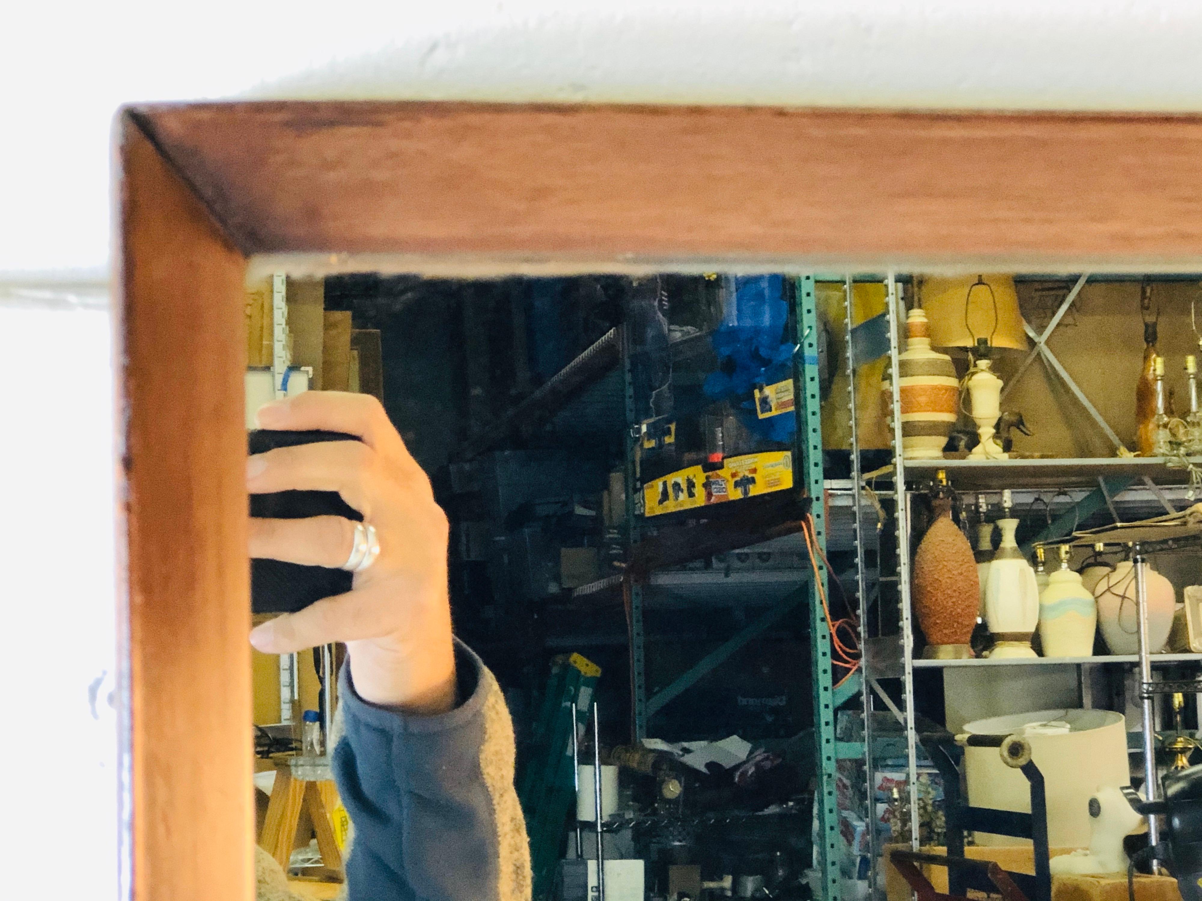 1960s beveled walnut wood wall mirror. He wood has been refinished and is in excellent condition. The mirror has a light fog from age. Can only see in very bright light. No hardware. No marks.