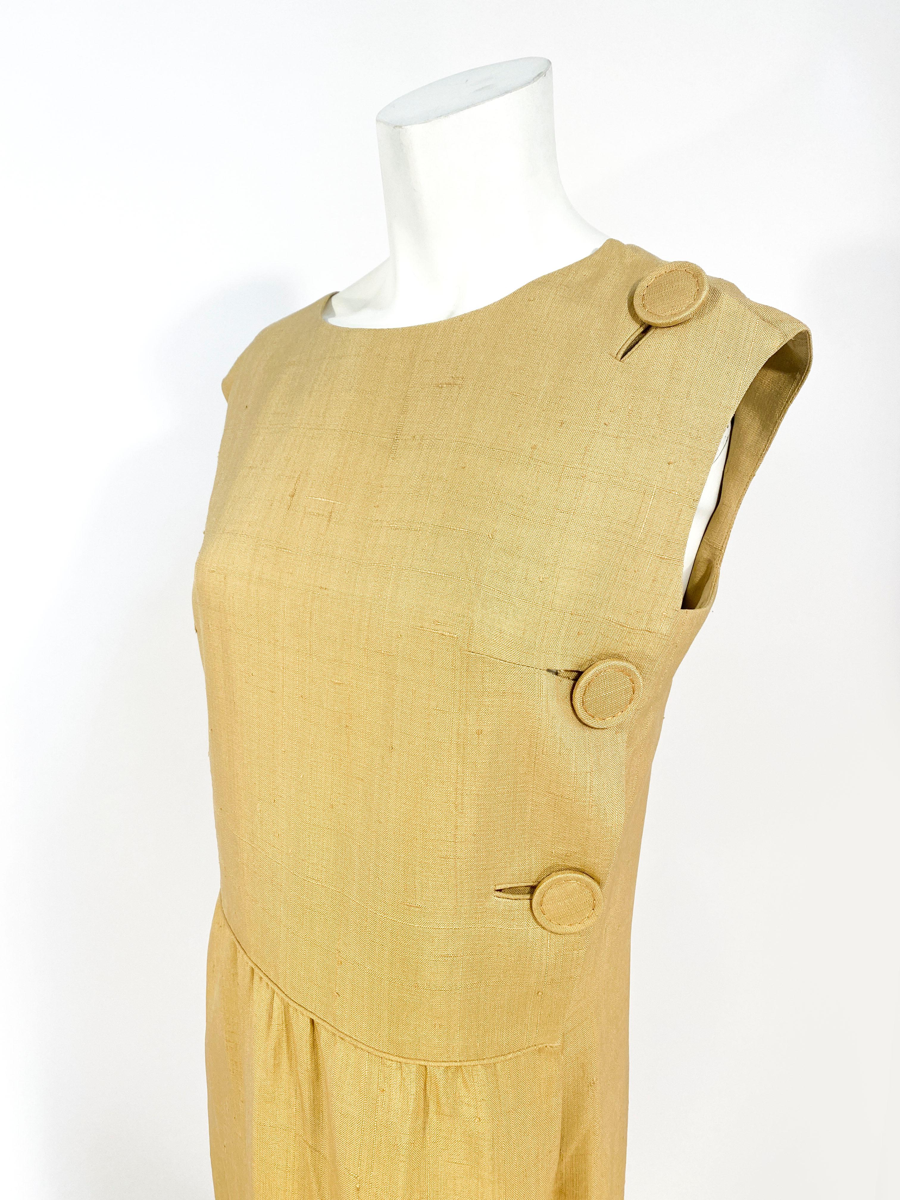 1960s B.H. Wragge drop-waist day dress in a mustard yellow raw silk. This piece features enlarged hand covered designer buttons and in-set button holes.