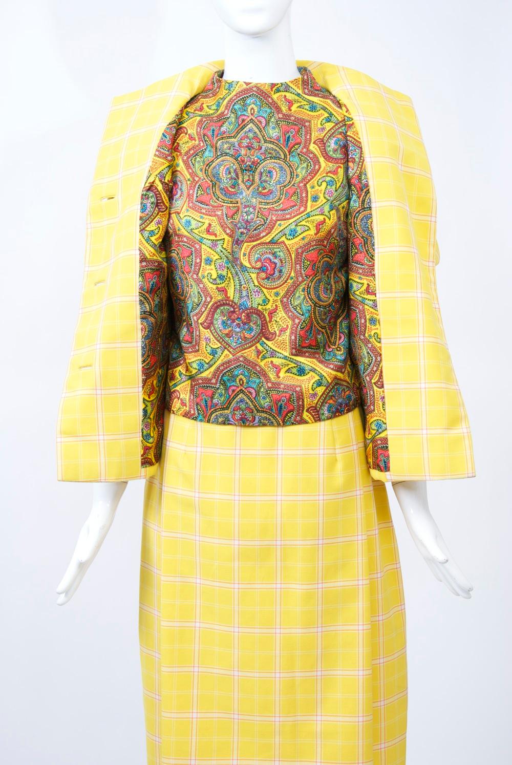 Early Bill Blass spring suit in yellow windowpane plaid worsted wool, the jacket lining and sleeveless shell in complementary silk paisley. The short-sleeve jacket features a funnel neckline, diagonal seaming from underneath the raglan sleeves to