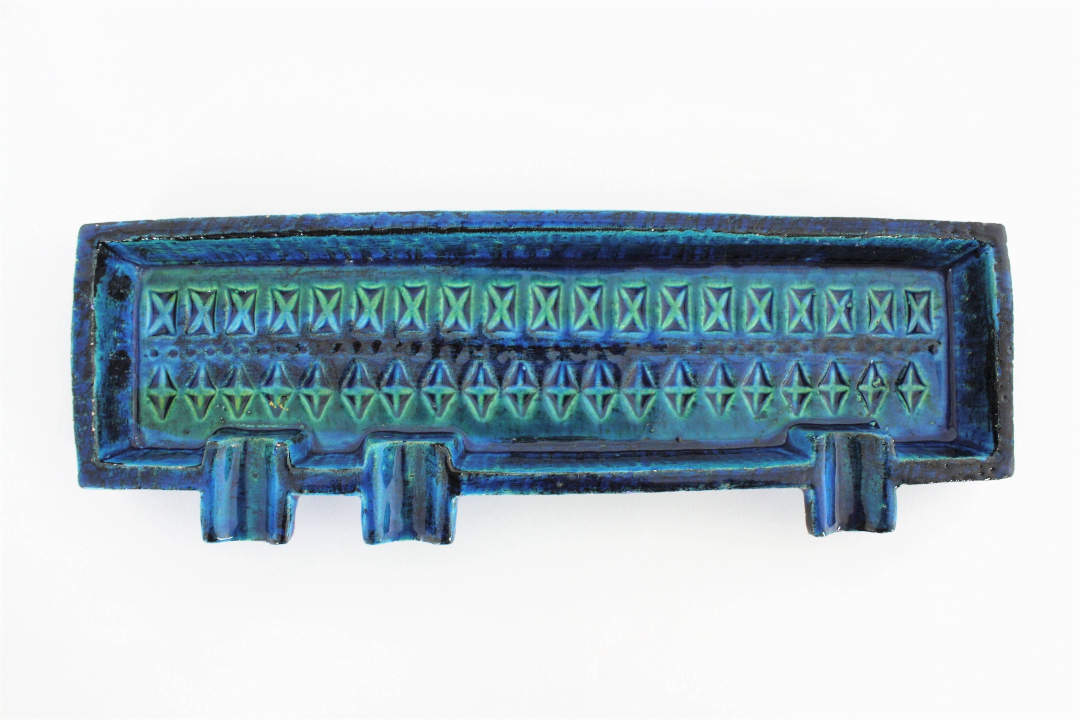 Italian handcrafted blue glazed ceramic rectangular ahstray with hand-carved geometric designs in cobalt blue and turquoise colors. Rimini blue collection designed by Aldo Londi for Bitossi, Italy, 1960s.
Lovely to use as ashtray but also as a