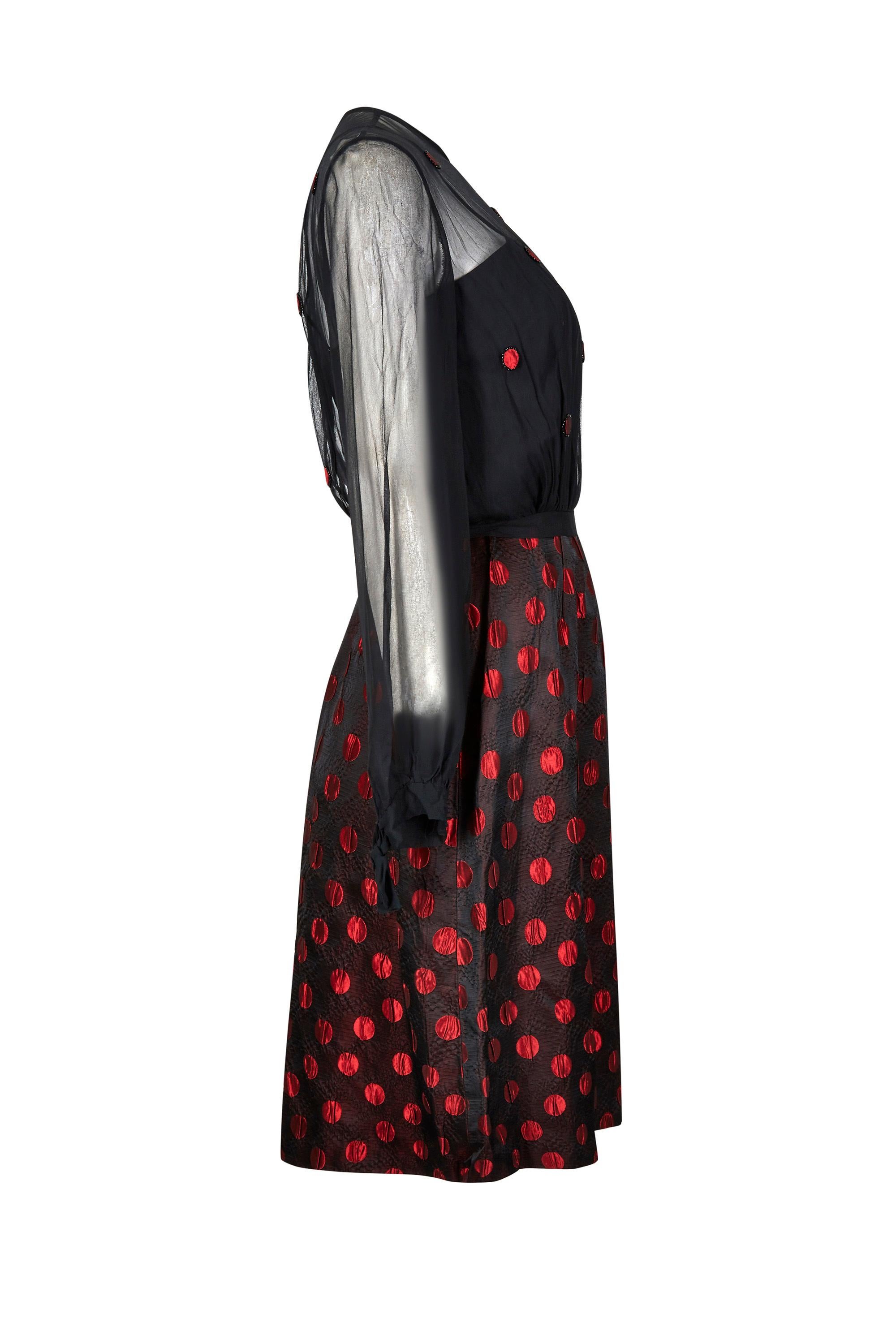 This 1960s red and black polka dot American demi-couture ensemble is in beautiful vintage condition and of excellent quality; however, is unlabelled and so the designer remains unknown. The set is comprised of a dress and jacket in chiffon and silk
