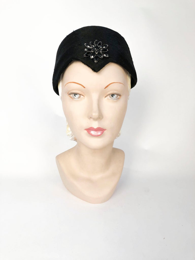 1960's Black Beaver Felt Modified Pillbox Hat with fastened black rhinestone accent centered on an inverted peak. 