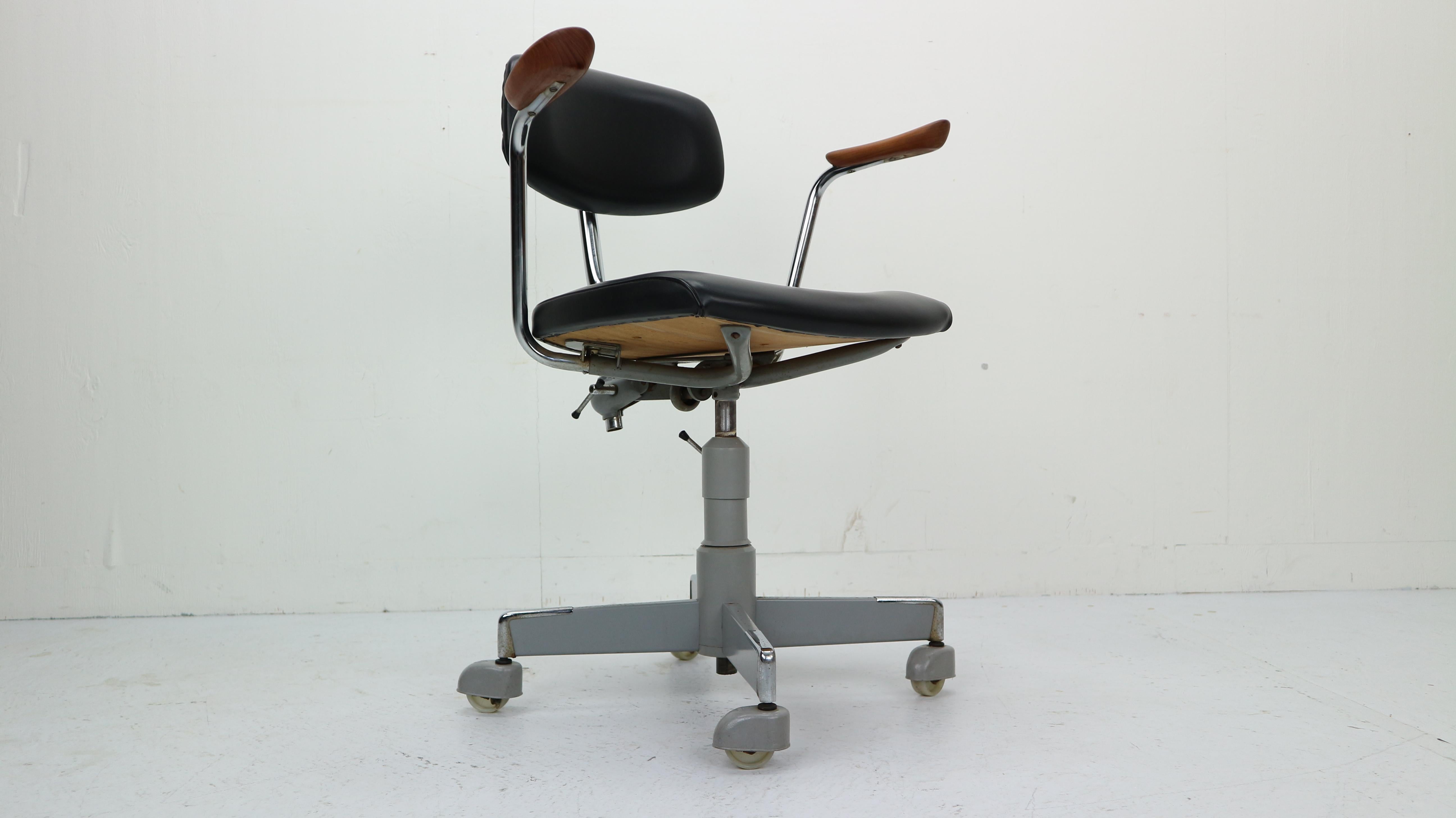 A swivel office desk chair on castors from the 1960s

with teak arm rests and black vinyl upholstered seat and back

The back and the seat height are adjustable.

Made in Norway by Hag furniture.

