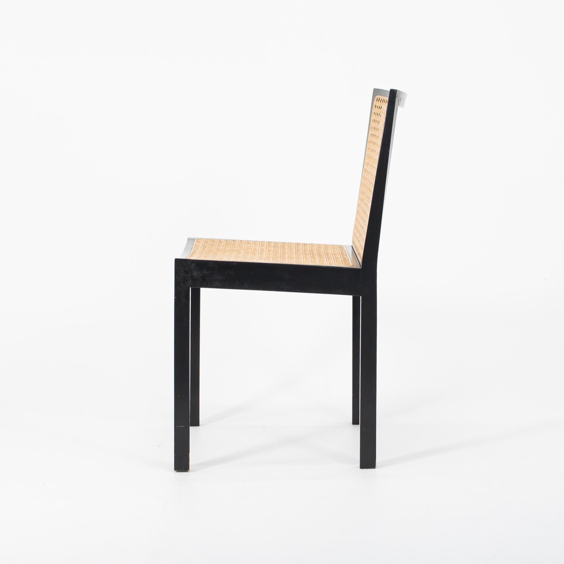 This is a set of four Bankstuhl caned dining chairs, designed by Willy Guhl. This simple solid model of dining chair is composed of a wood frame with a caned seat and back. 
This silhouette was designed by Guhl in 1959, and this set was manufactured