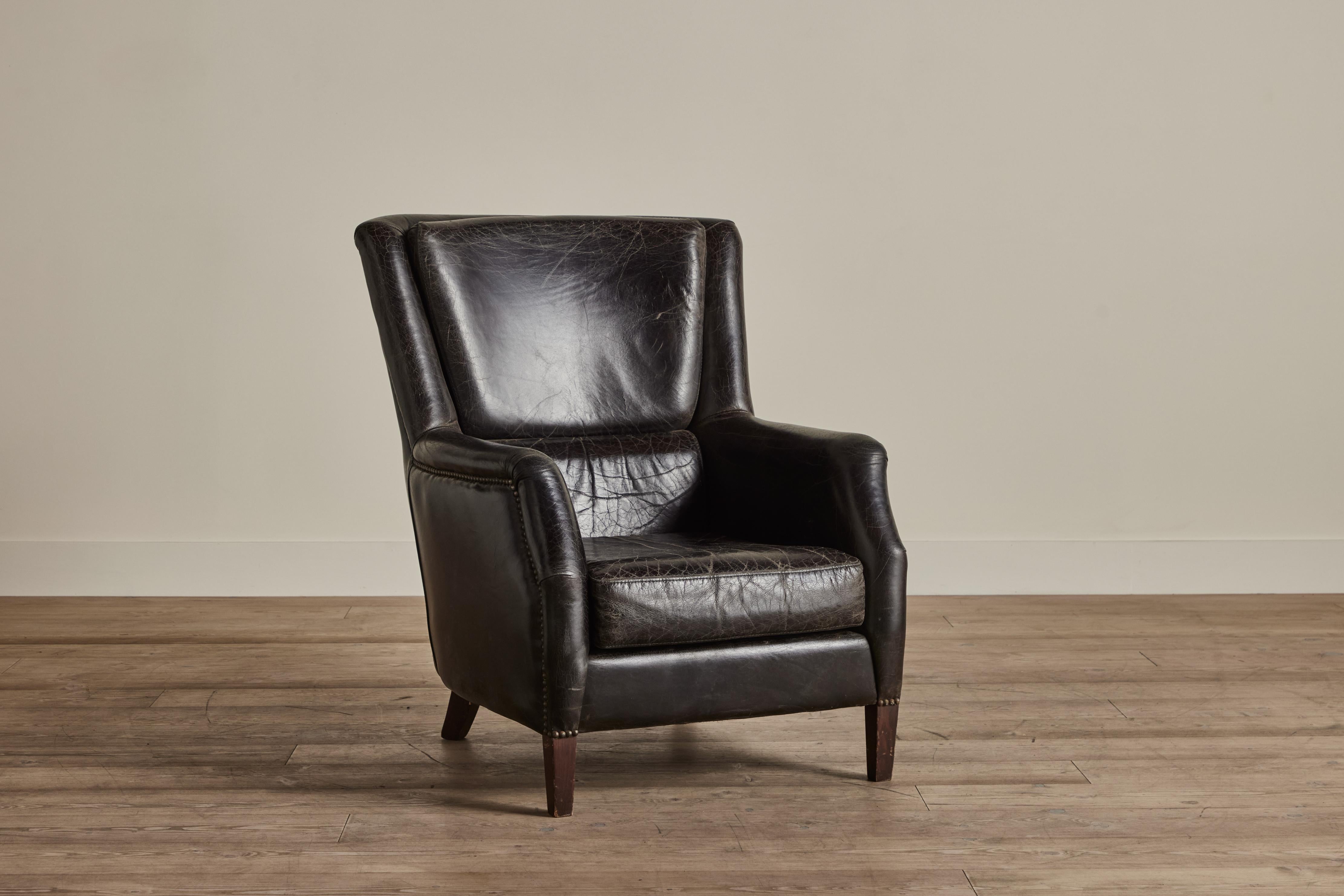 Schwarzer Lederstuhl mit hoher Rückenlehne aus den 1960er Jahren aus Dänemark. Einige Abnutzungserscheinungen auf dem Leder, die mit dem Alter und dem Gebrauch vereinbar sind. 