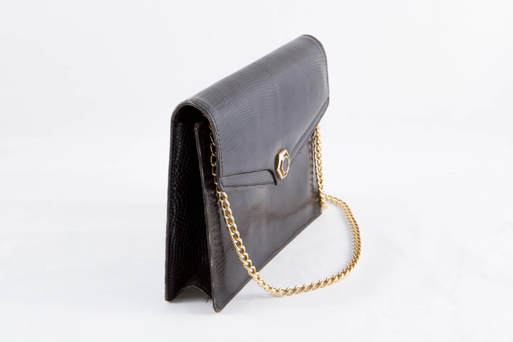 1960s black evening bag featuring a lizard effect leather outside, an inside black leather lining, a detachable gold tone shoulder chain, a front snap closure, inside 2 small pockets. 
In excellent vintage condition. Made in France.
Measurements: