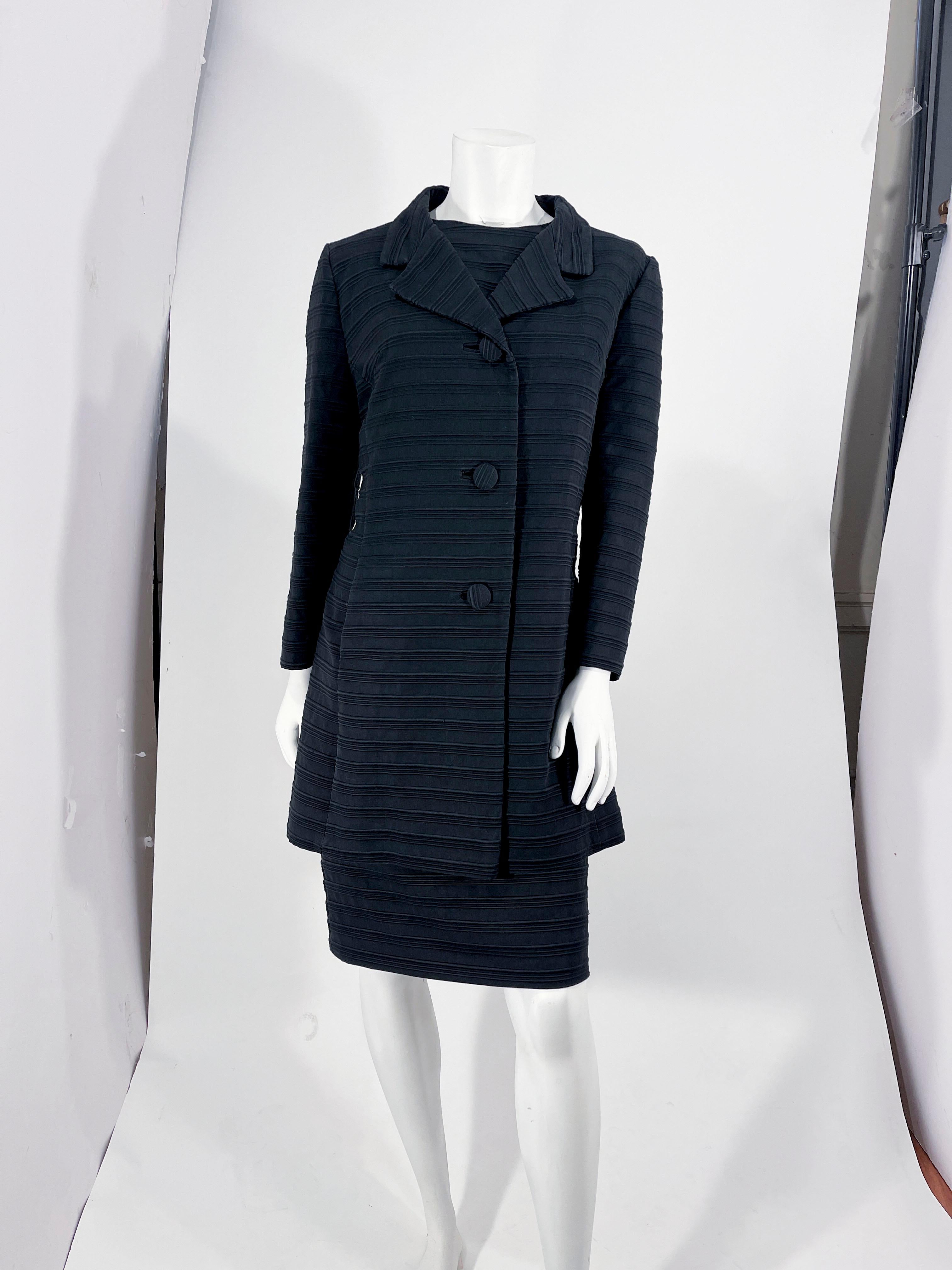 1960s Lilli Ann black textured matching dress and coat ensemble. The sleeveless shift dress features a high scoop neckline, and a full black lining. The back of the dress has a metal zippered closure. 

The matching coat has three-quarter length