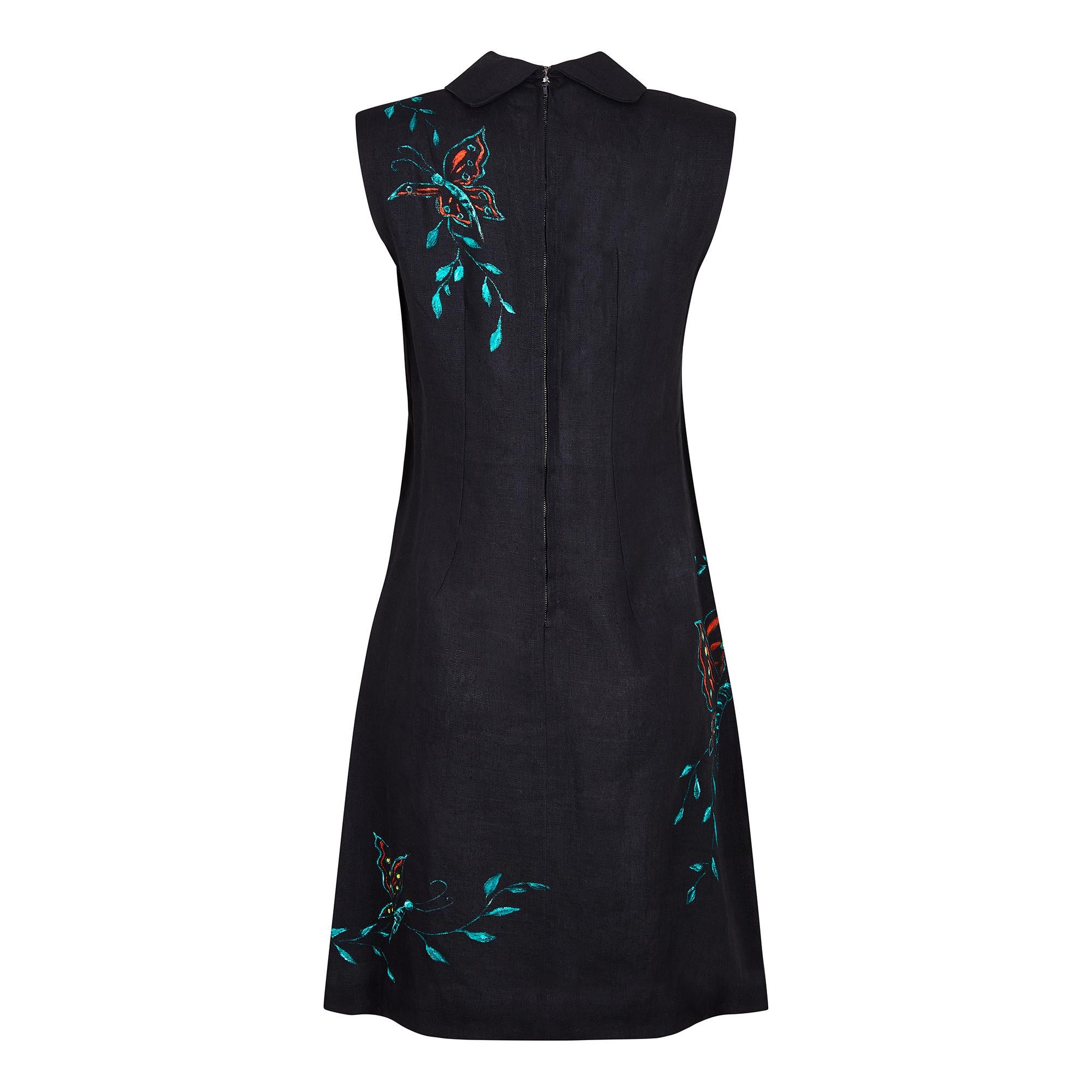 A superb 1960s black linen shift dress with hand-painted butterfly motifs in green, orange, red & yellow. The hand-painted butterflies comprise of 3 large butterfly outlines to the front; 1 that broaches the side and 2 smaller butterfly motifs to