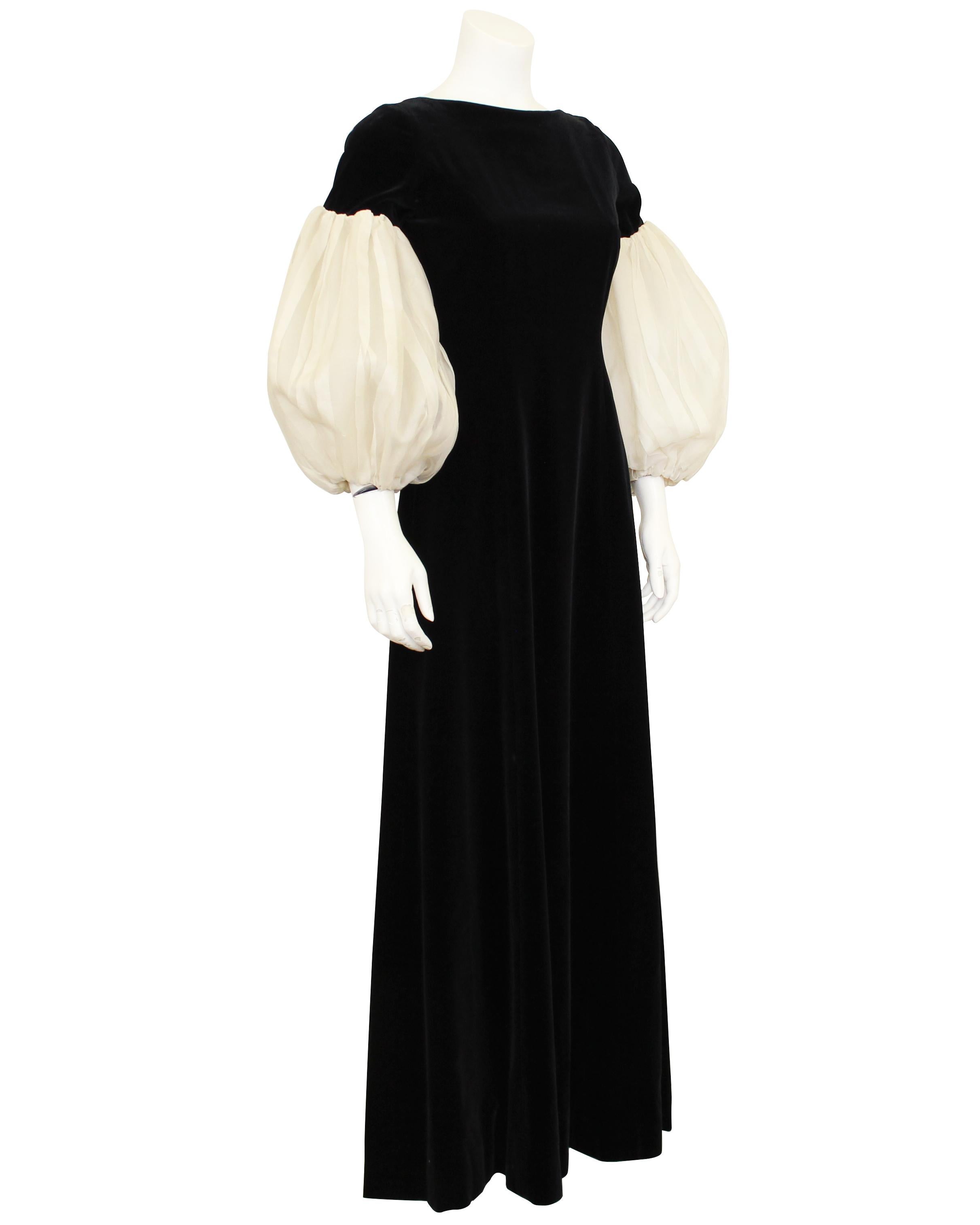 Exquise robe anonyme vintage datant des années 1960. Luxueux velours noir de jais avec manches bouffantes plissées en organza de soie crème contrastant. Encolure bateau sur le devant et en V dans le dos. Les manches sont dotées d'une doublure rigide