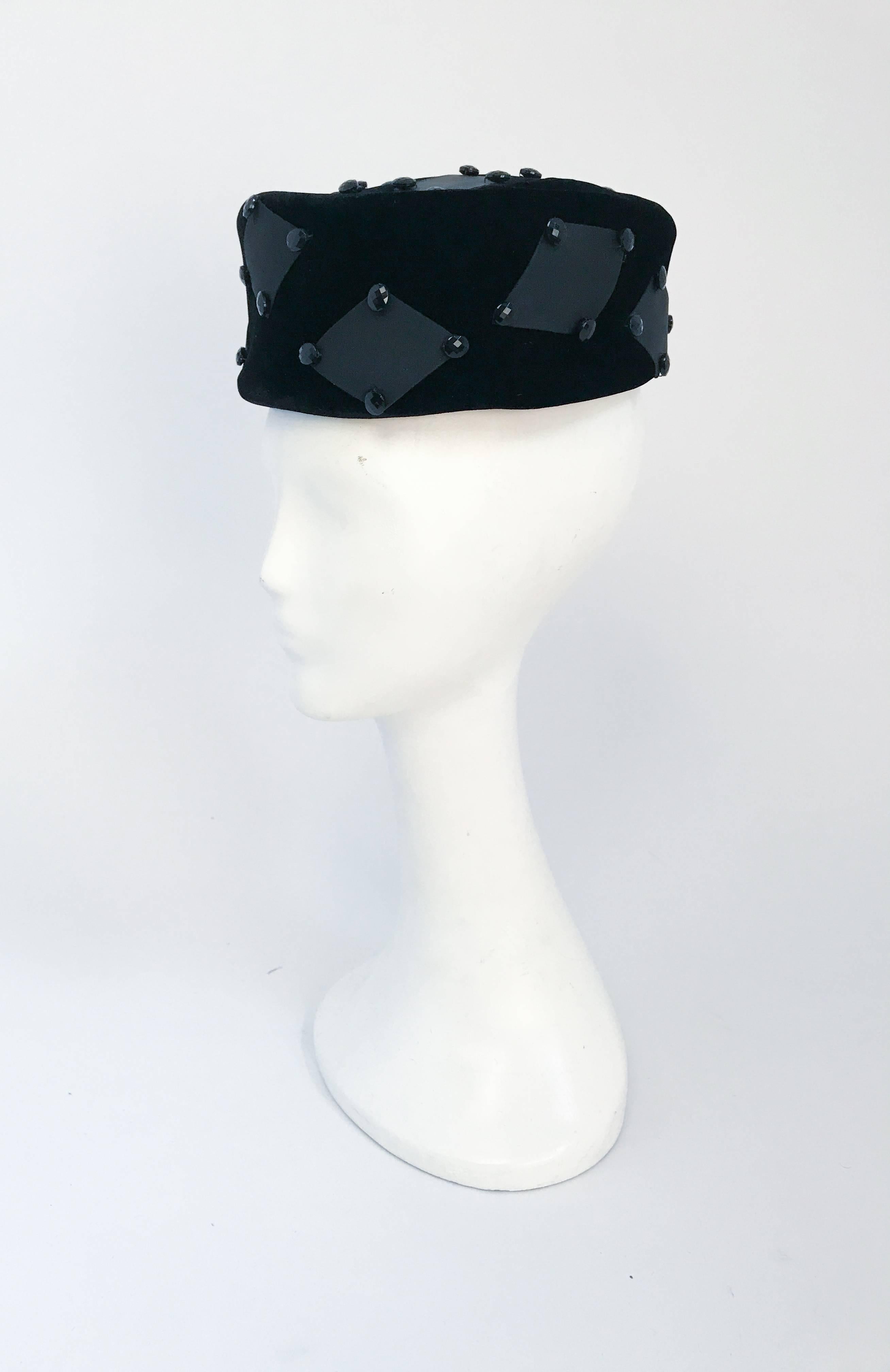 Cappello anni '60 in velluto nero con accenti rettangolari. Cappello in velluto nero con accenti rettangolari in raso e perline. Dimensioni aperte.