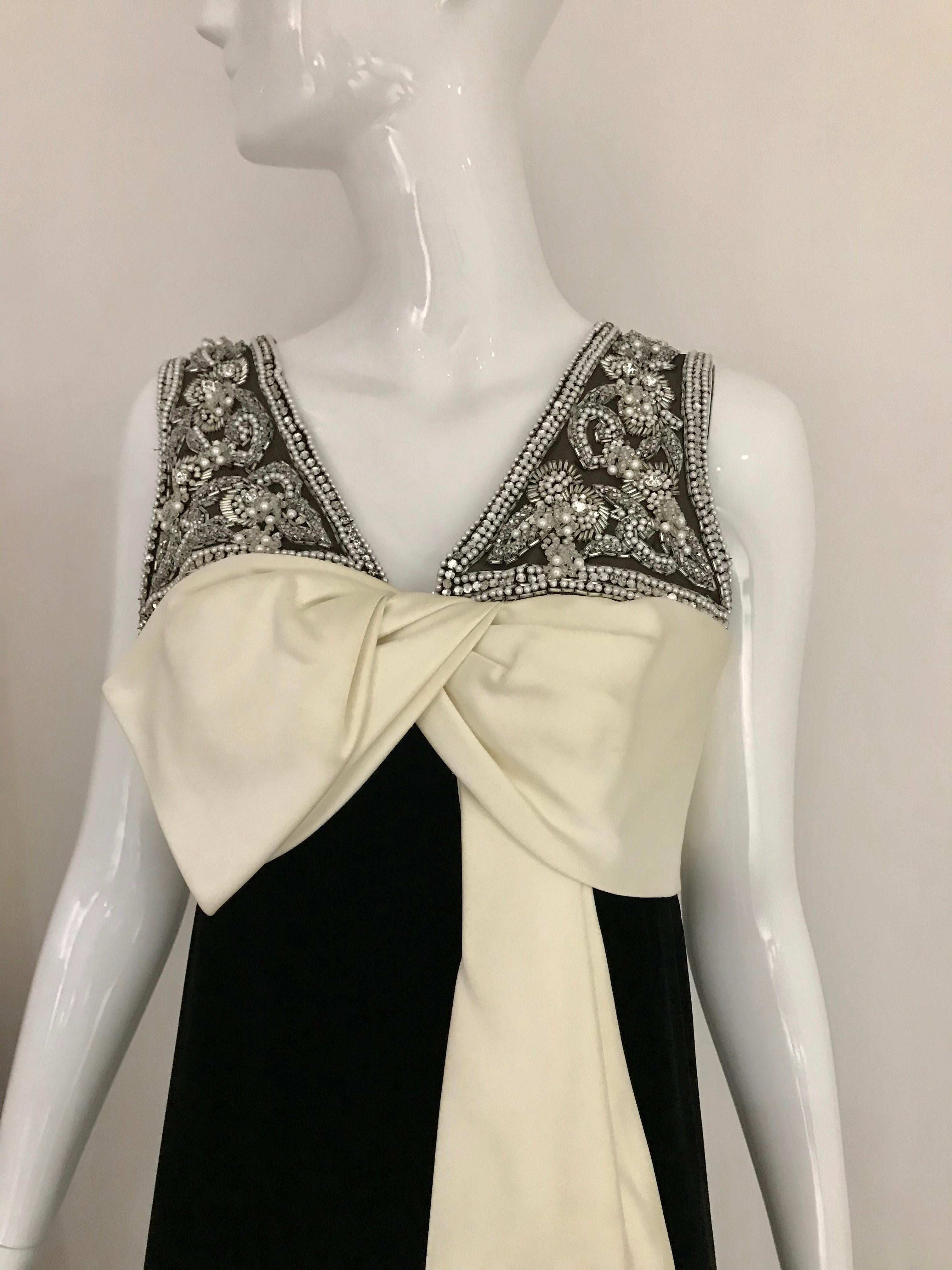 Elegant 1960s Black Velvet sleeveless gown with creme silk bow and embellished with clear bugle beads. 
Size : 6
** tiny tear on the armpit area ( see image) 
Dress has been freshly dry cleaned.