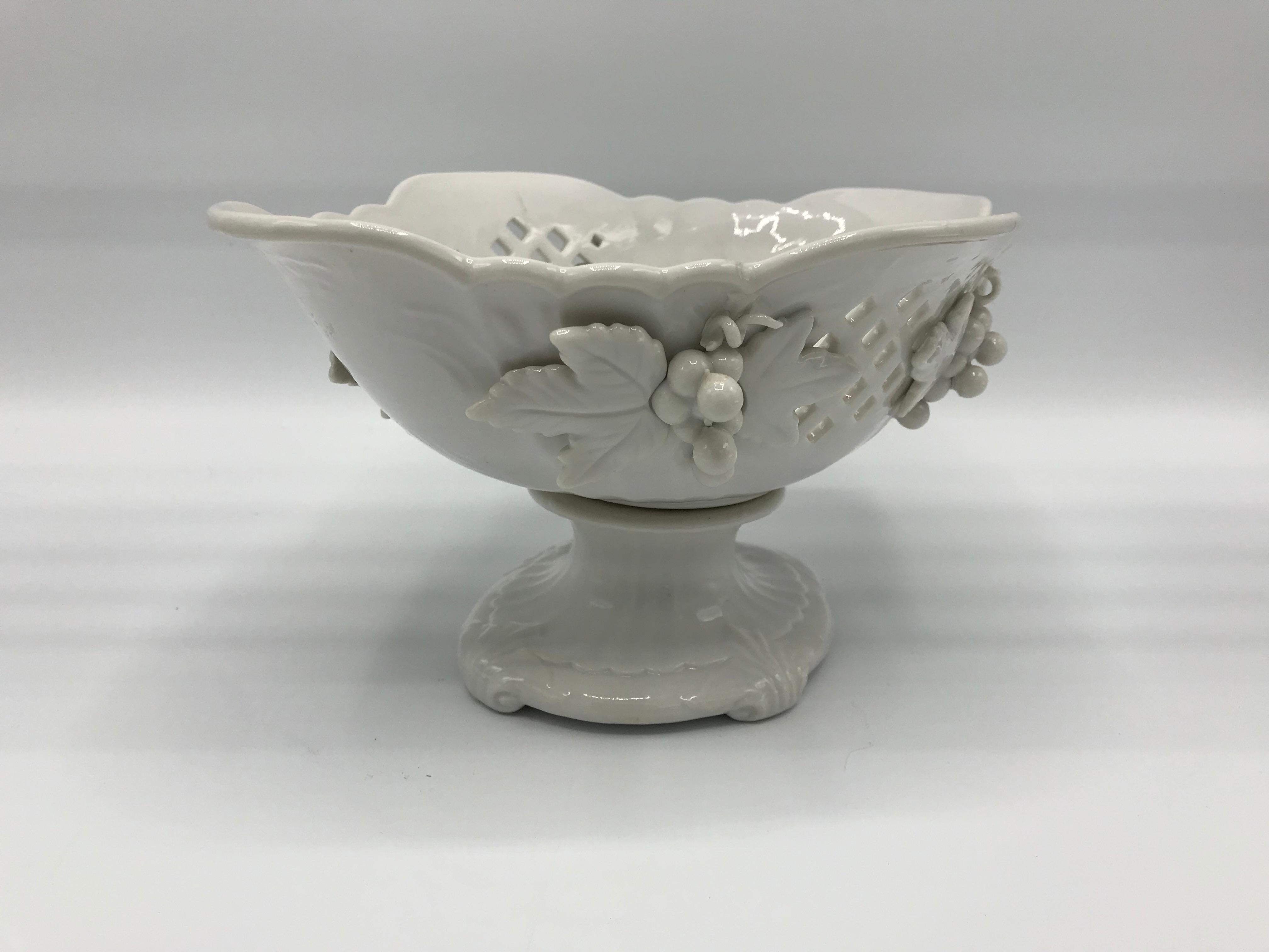 Offered is a stunning, 1960s Blanc de Chine porcelain compote bowl. The piece has a gorgeous pierced detailing on the two longer sides and a sculptural grape motif.