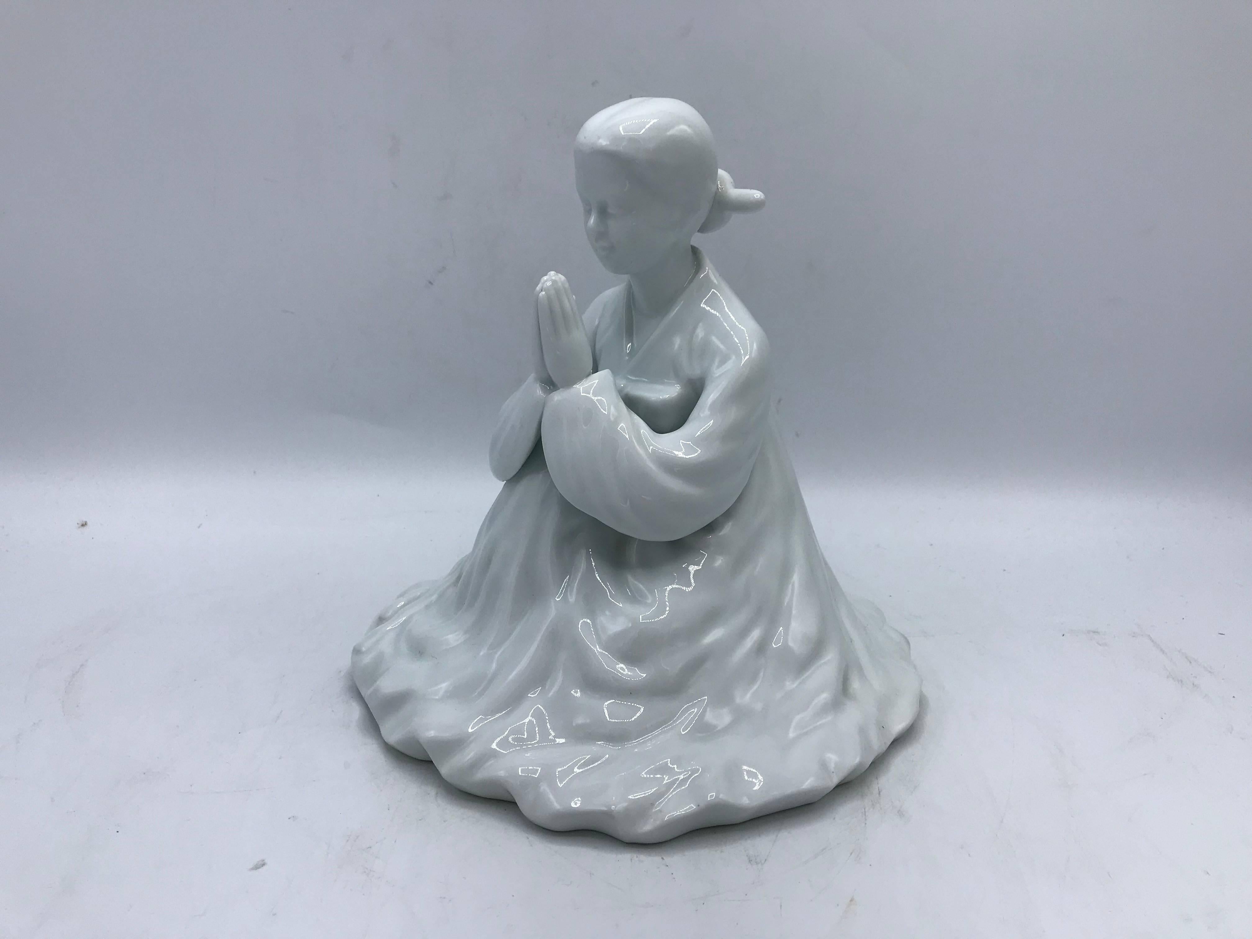 Listed is a beautiful and large, 1960s porcelain Blanc de Chine geisha sculpture. The ornate piece has the geisha in a praying position in her kimono.
