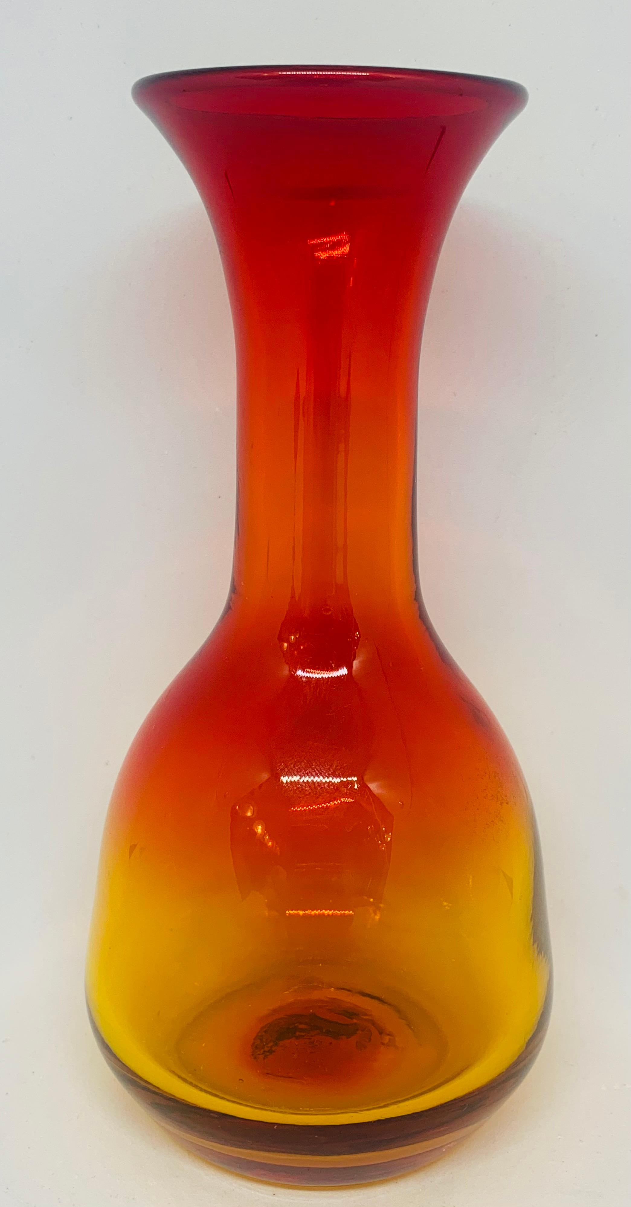 A small 1960s Blenko style hand blown tangerine or amberina glass vase. I am sure it's Blenko but with no manufacturer's label I can't be 100% certain. In very good vintage condition. Made in the USA. 

Dimensions: Diameter: 9cm, height: 17 1/2cm.