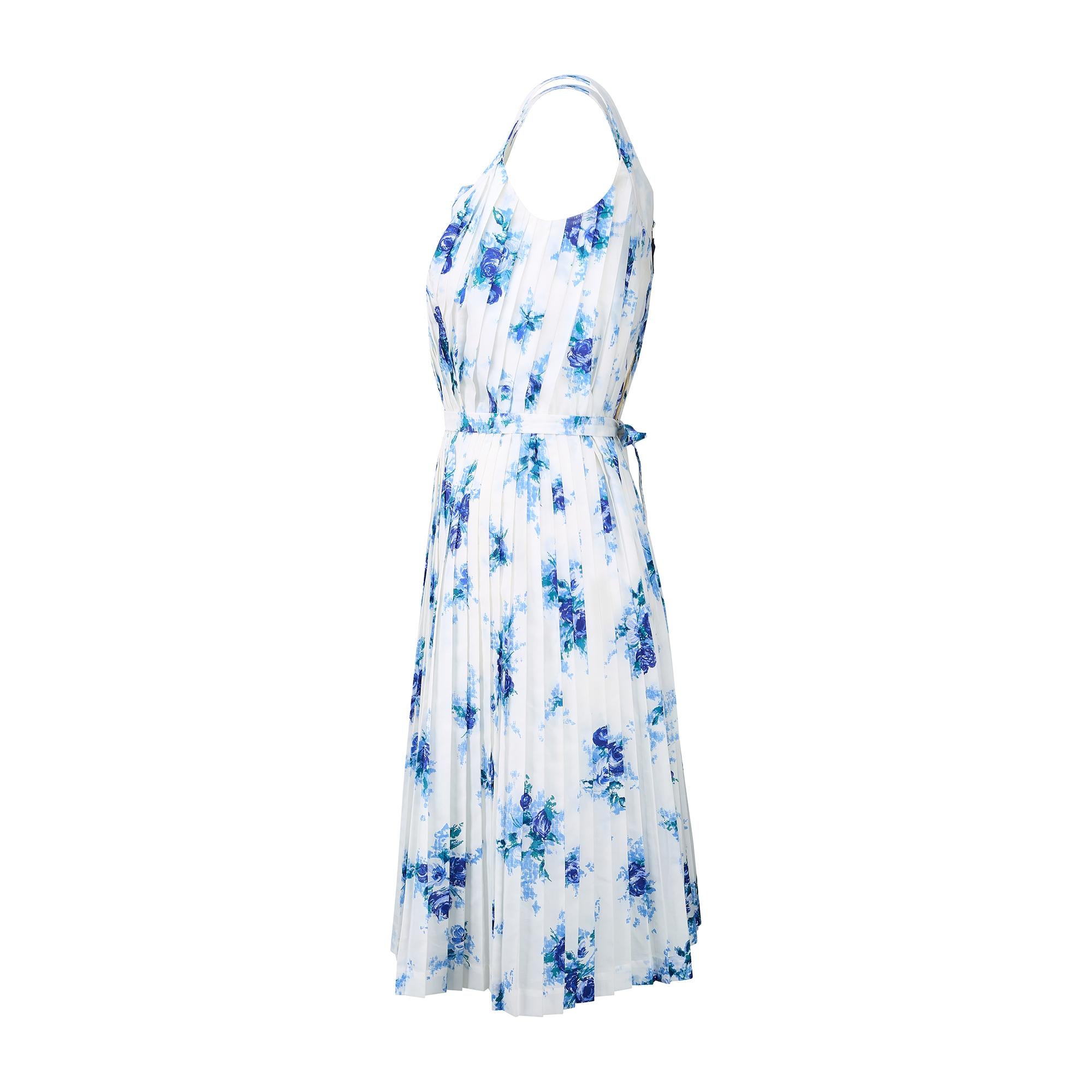 Cette robe d'été des années 1960 a été confectionnée en France par une couturière compétente et n'est pas étiquetée. Fabriqué en nylon doux au toucher et imprimé de grappes de roses bleu royal avec des feuilles sarcelles sur un fond bleu pâle. Le