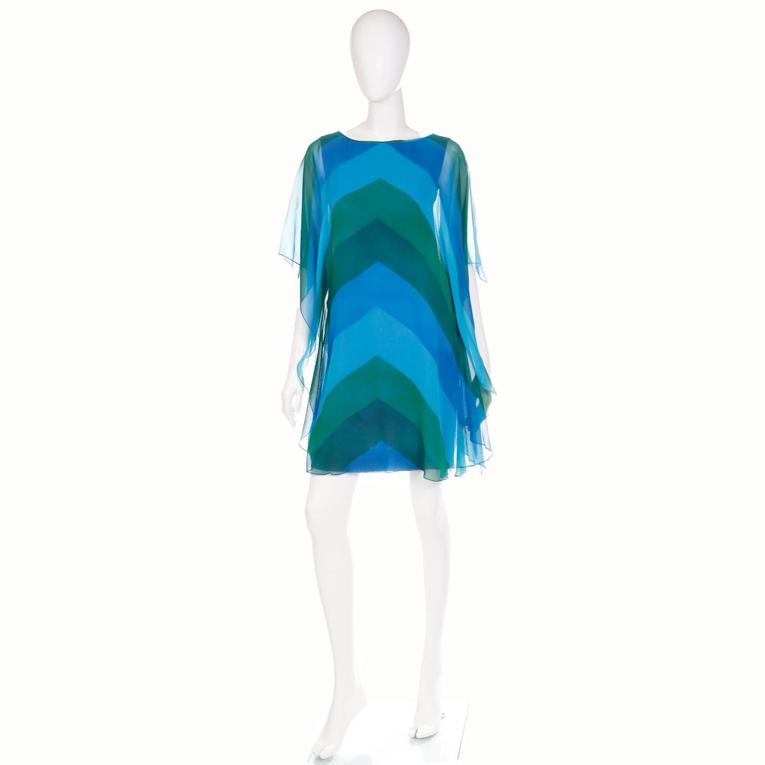 This stunning 1960's vintage dress is one of the prettiest Summer dresses we have seen.  The under dress is a fitted purple sleeveless sheath, but it is accentuated with an overlay of exquisite blue and green silk chiffon in a chevron stripe print.