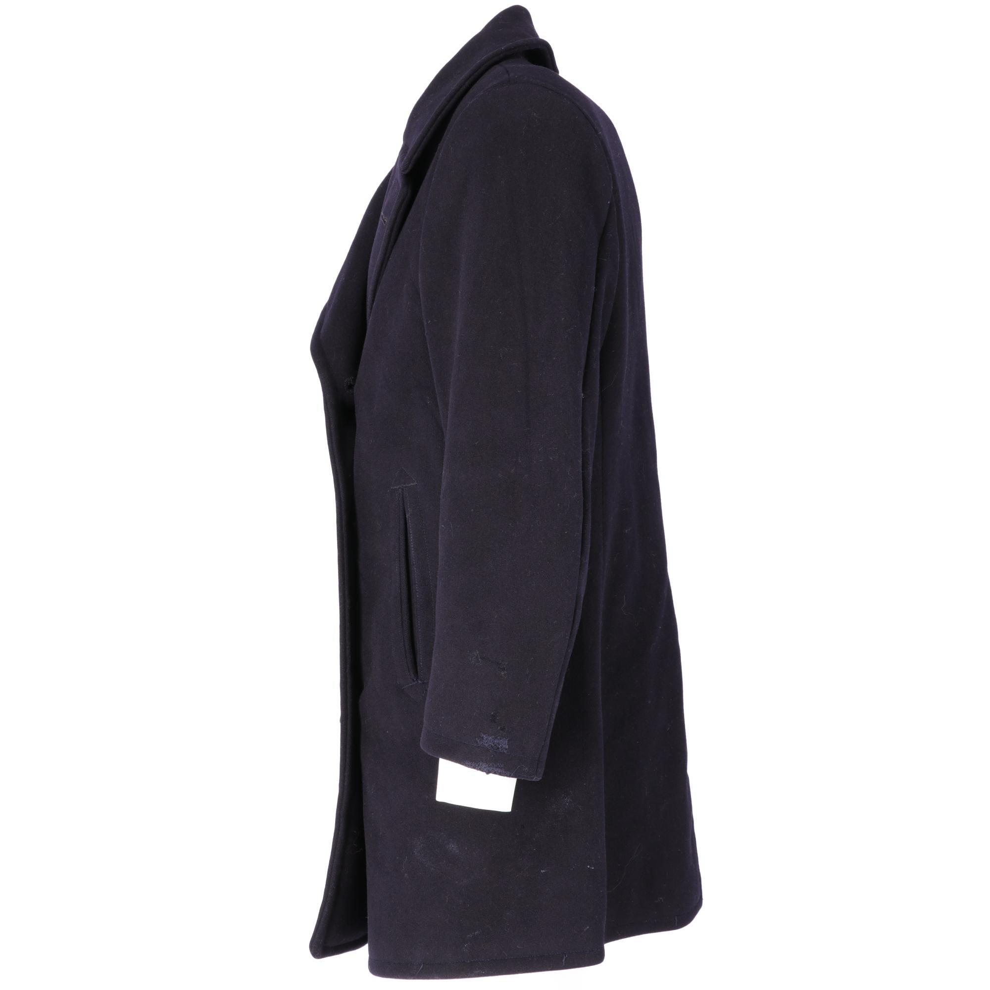Dark blue wool coat with classic lapels collar, long sleeves, double-breasted button closure with buttons with a decorative anchor, two side welt pockets, back slit, lined and inside pockets.

The item shows slight signs of wear on the garment, the