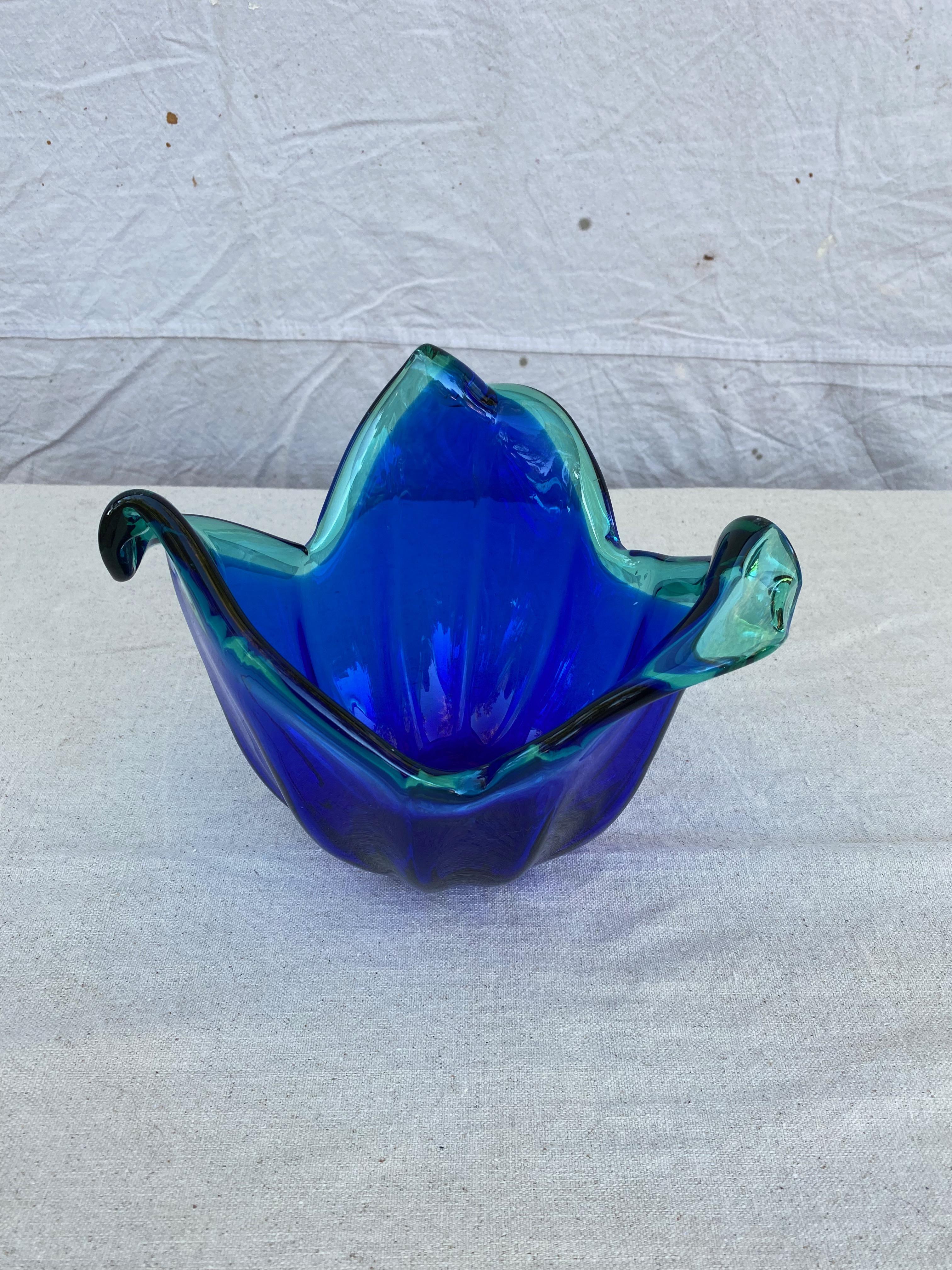 An interesting small Murano dish in a rich cobalt blue color having a lighter teal green variation at the top. The dish has stylized petal edges and has the original manufacturers label. 

Italian, 1960s.