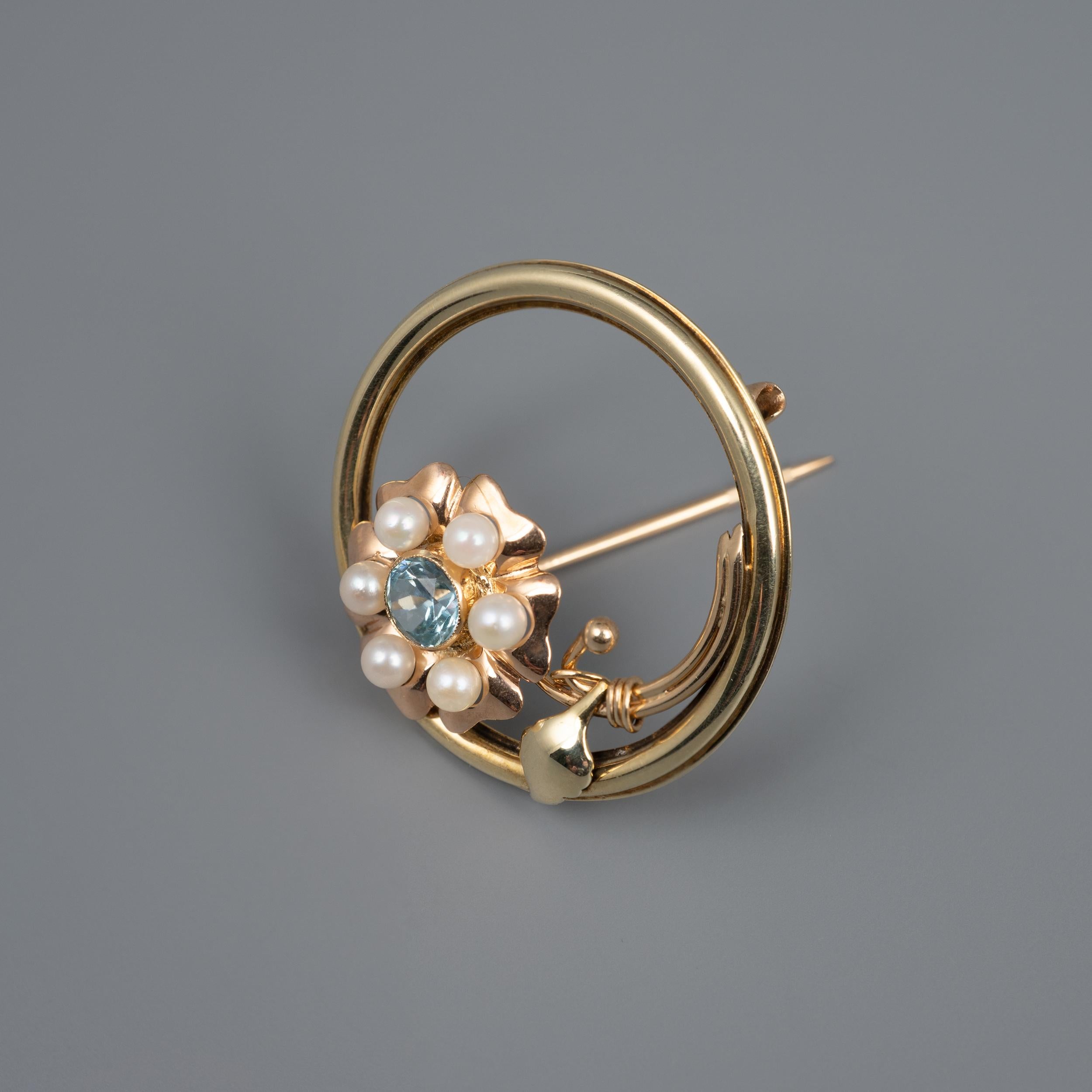 This fantastic 1960s blue zircon and cultured pearl flower brooch is crafted in 2 tone rose and yellow gold - Circa 1960s jewelry

The circular brooch displays a beautiful flower with rose gold petals. The flower is set with a stunning ice blue