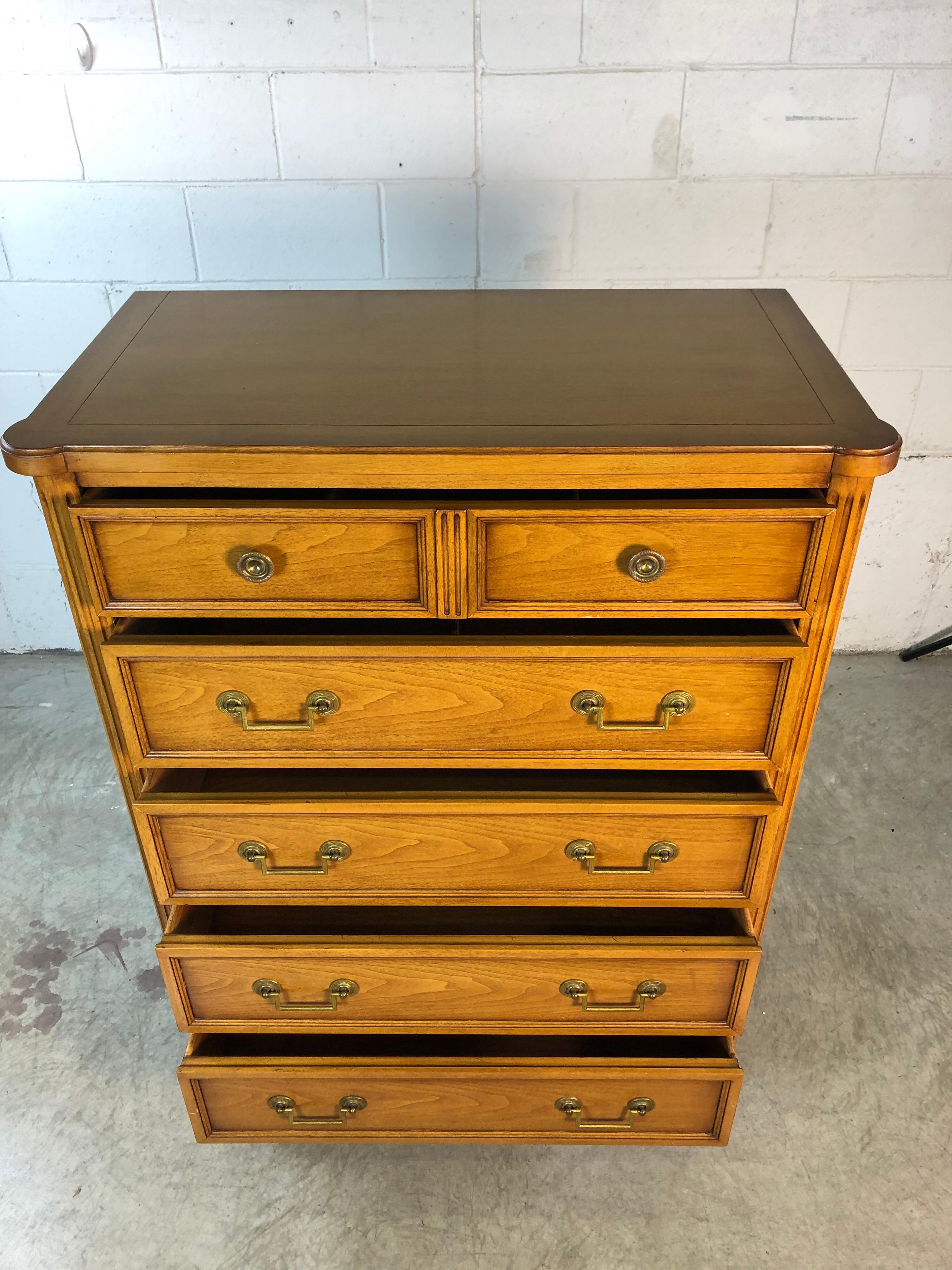 Vintage 1960s Bodart Furniture Co tall highboy Sheridan style mahogany wood dresser. The dresser has column sides and brass accents along the bottom of the columns. The dresser has five deep drawers for storage and brass pulls. Marked in the drawer.