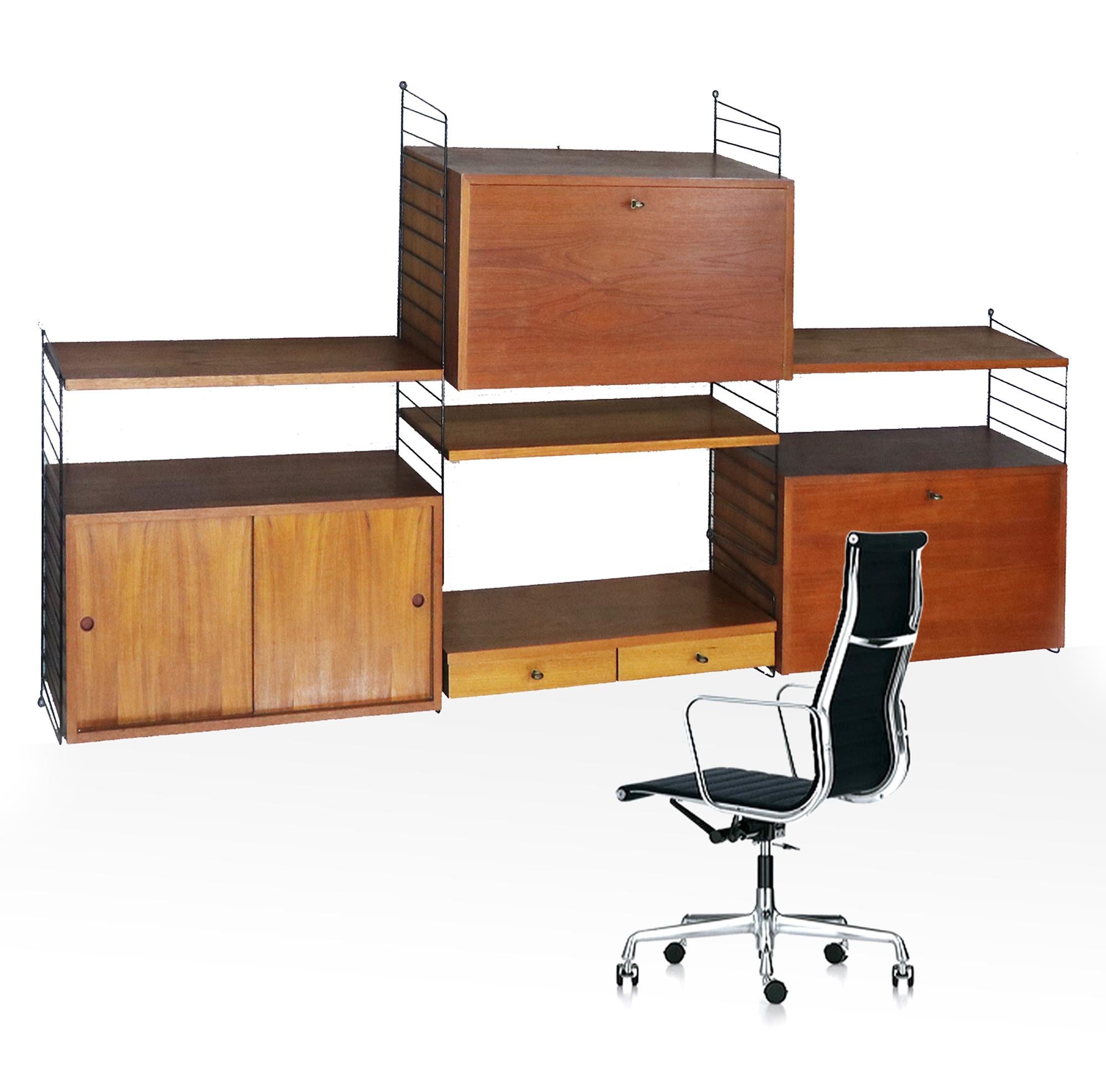 Modular and adaptable shelving system consisting of teak shelving mounted between ladder elements in black lacquered wire steel, three cabinets and one desk / board with two drawers in teak.
The wall unit is easy to install and stabile, can be
