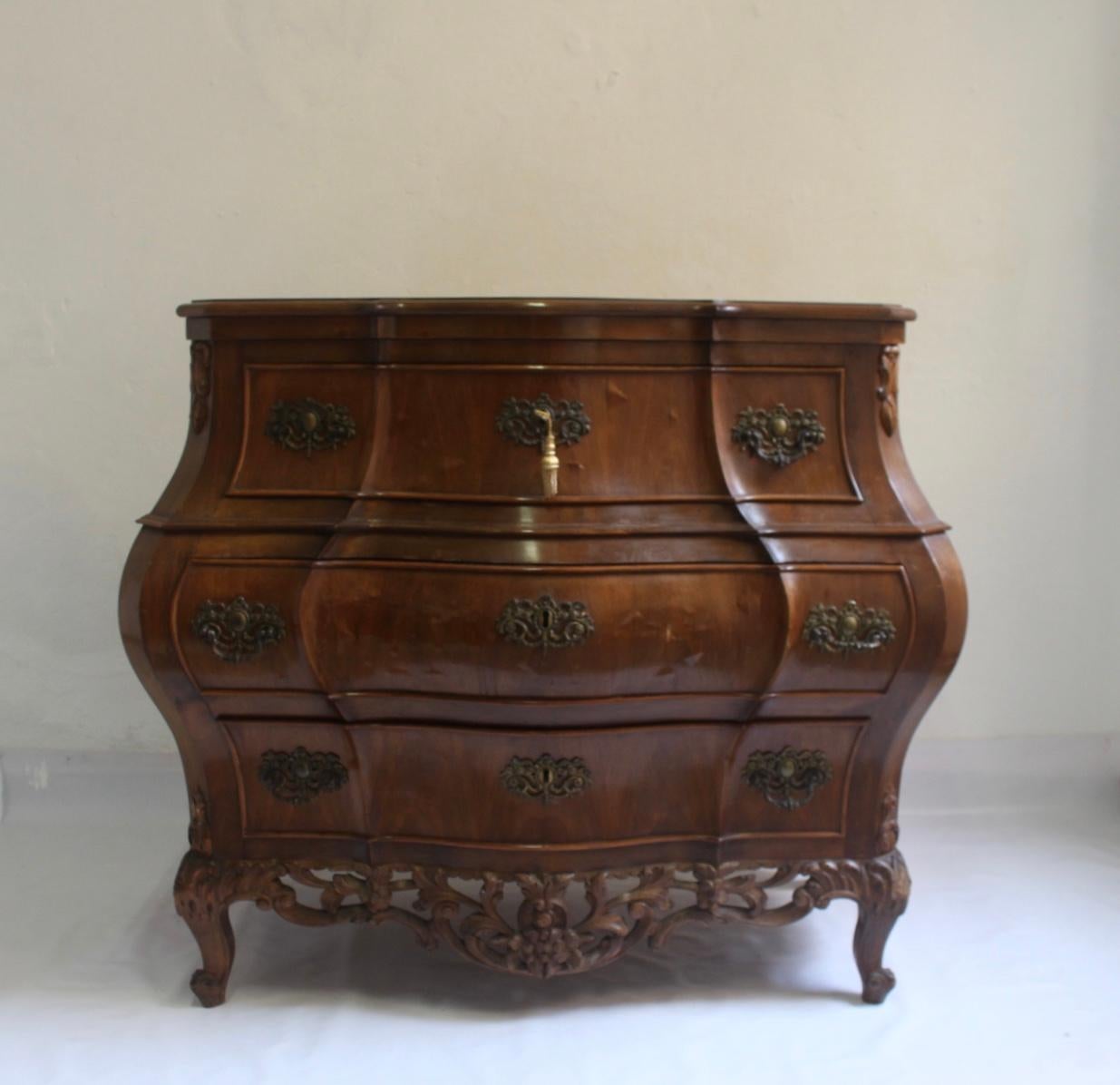 Midcentury handcrafted Bombé Louis XV Rococo Bombe commode or chest of drawers by Mariano García, Valencia, Spain, circa 1960s.
Item has chips to veneer, and some marks at one leg(pictured) but the piece remains in Good Vintage Condition.
Mariano