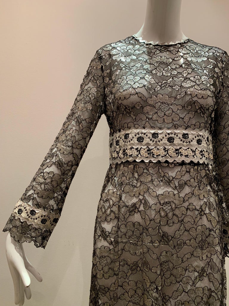 A 1960s Eloise Curtis for Happenstance - Bonwit Teller - black and silver floral lace maxi dress with an Empire waistline decorated with ribbon and rick-rack.  Matching banding near hem and cuffs. Back zipper. Unlined--you decide how daring you dare